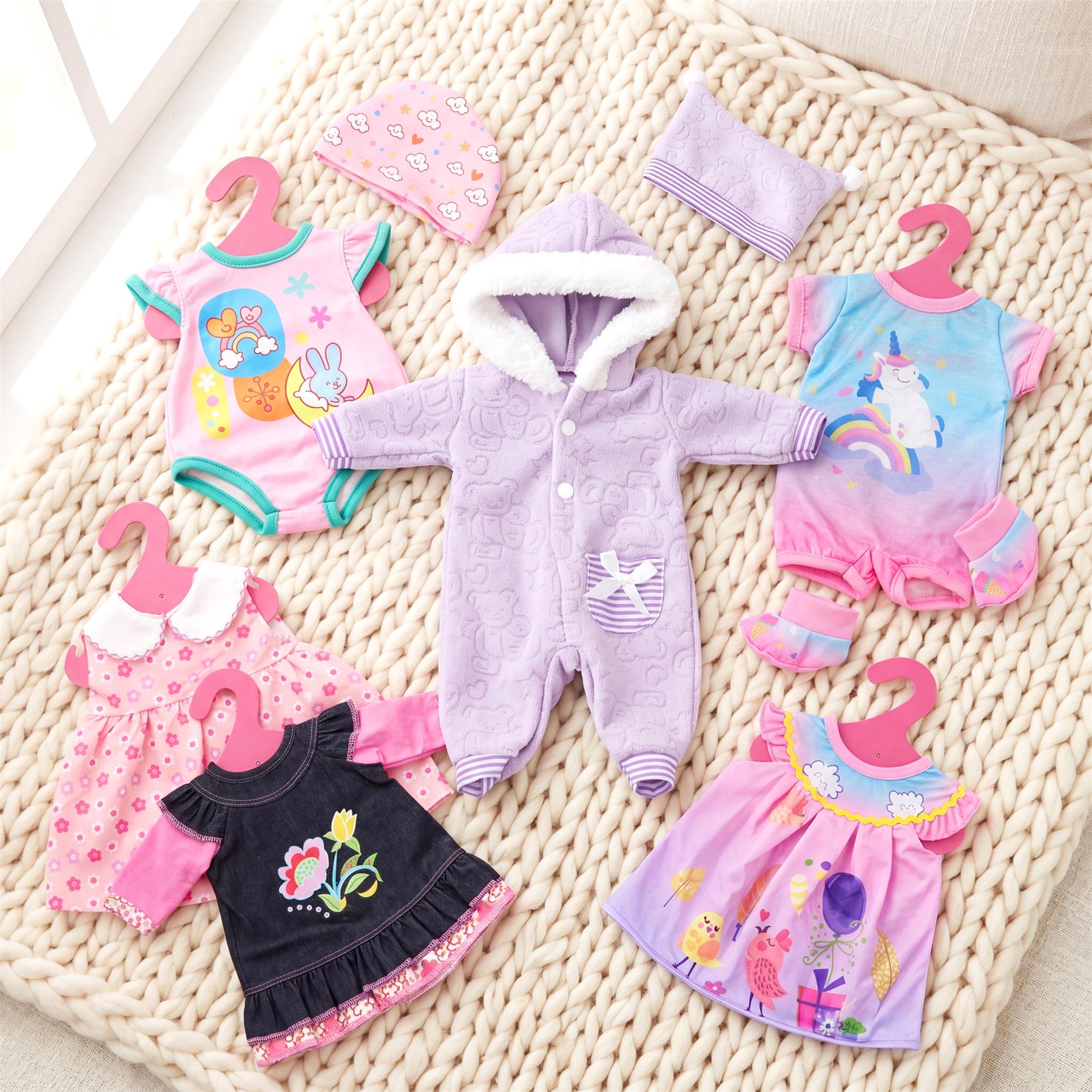 A collection of patterned doll clothes including sleepers, dresses, and accessories.