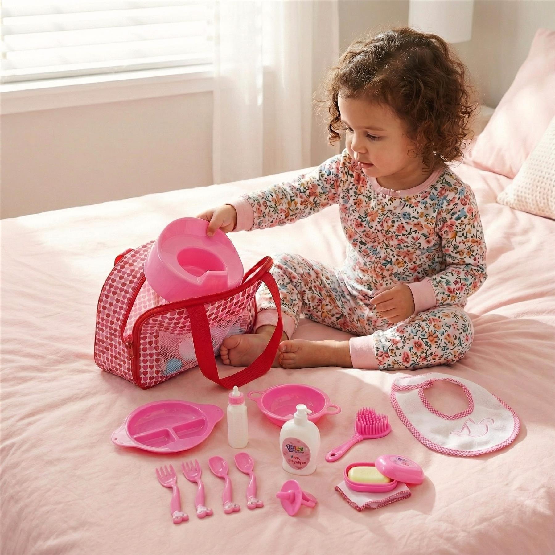 A young girl sits on a bed, surrounded by a pink and white playset. She holds a pink toilet seat, placing it into a pink toilet, while her toys and accessories, such as a pink baby bottle, a pink spoon, and a pink hairbrush, are scattered around her. The room is filled with soft, pink and white hues, creating a warm and inviting atmosphere. - The Magic Toy Shop