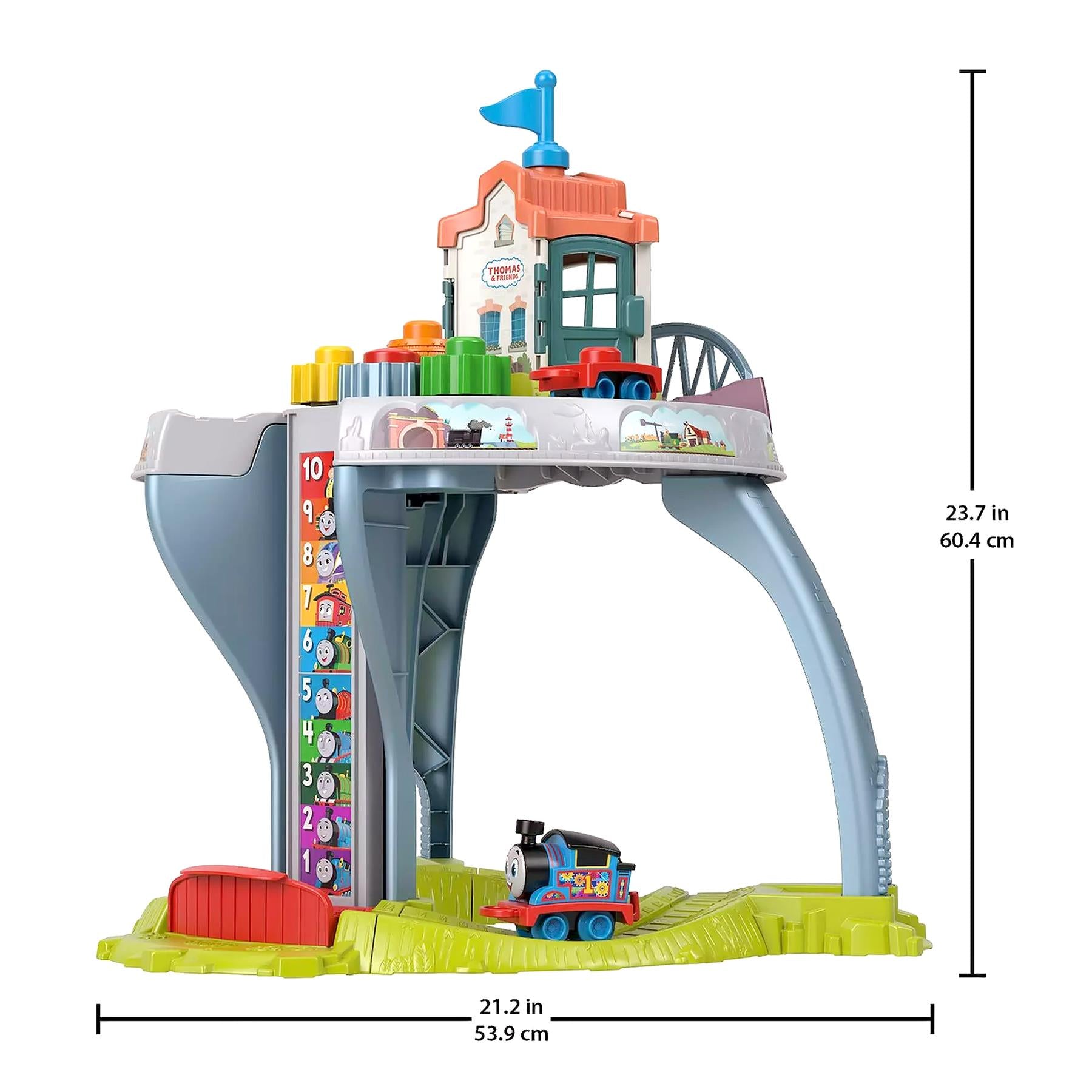 Modular train play table featuring a station building, track pieces, and locomotive toys.