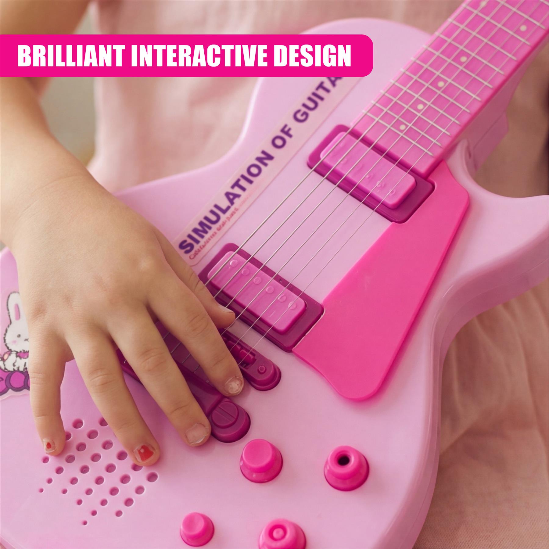 Child's hand plays a pink electric guitar toy with multiple interactive components.