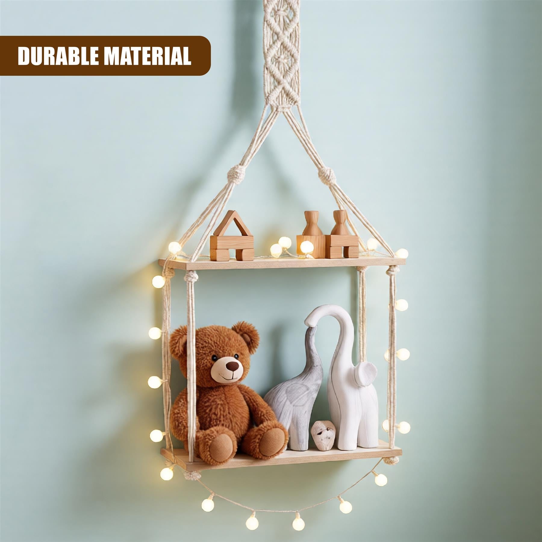 A wooden shelf with two shelves, suspended by a rope, holding various toys and objects. The top shelf has a wooden house, a block, and a small wooden object. The bottom shelf has a brown teddy bear, a white elephant, and a small wooden object. The background is a soft, pale green color. - The Magic Toy Shop