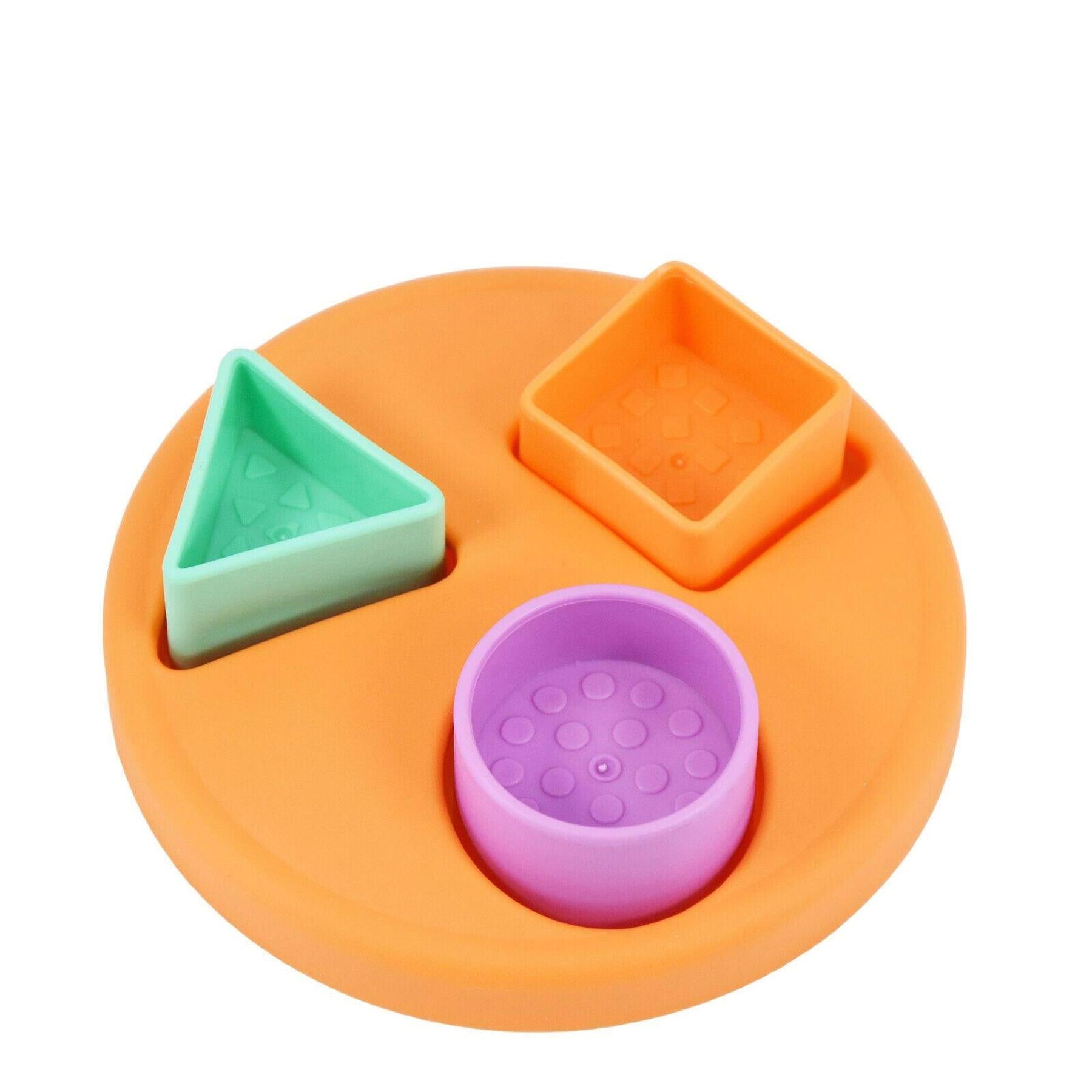 An orange toy base features three slots: a green triangle, an orange square, and a purple circle.