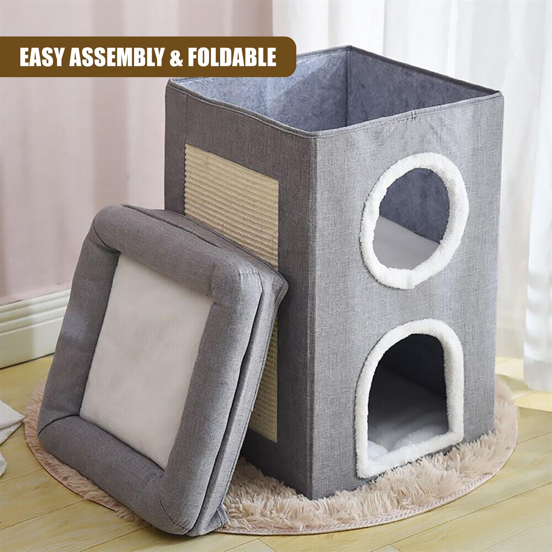 A grey cat house with a soft, plush interior and two windows. The house has a small door and a cat bed inside. It sits on a beige rug on a wooden floor. - The Magic Toy Shop