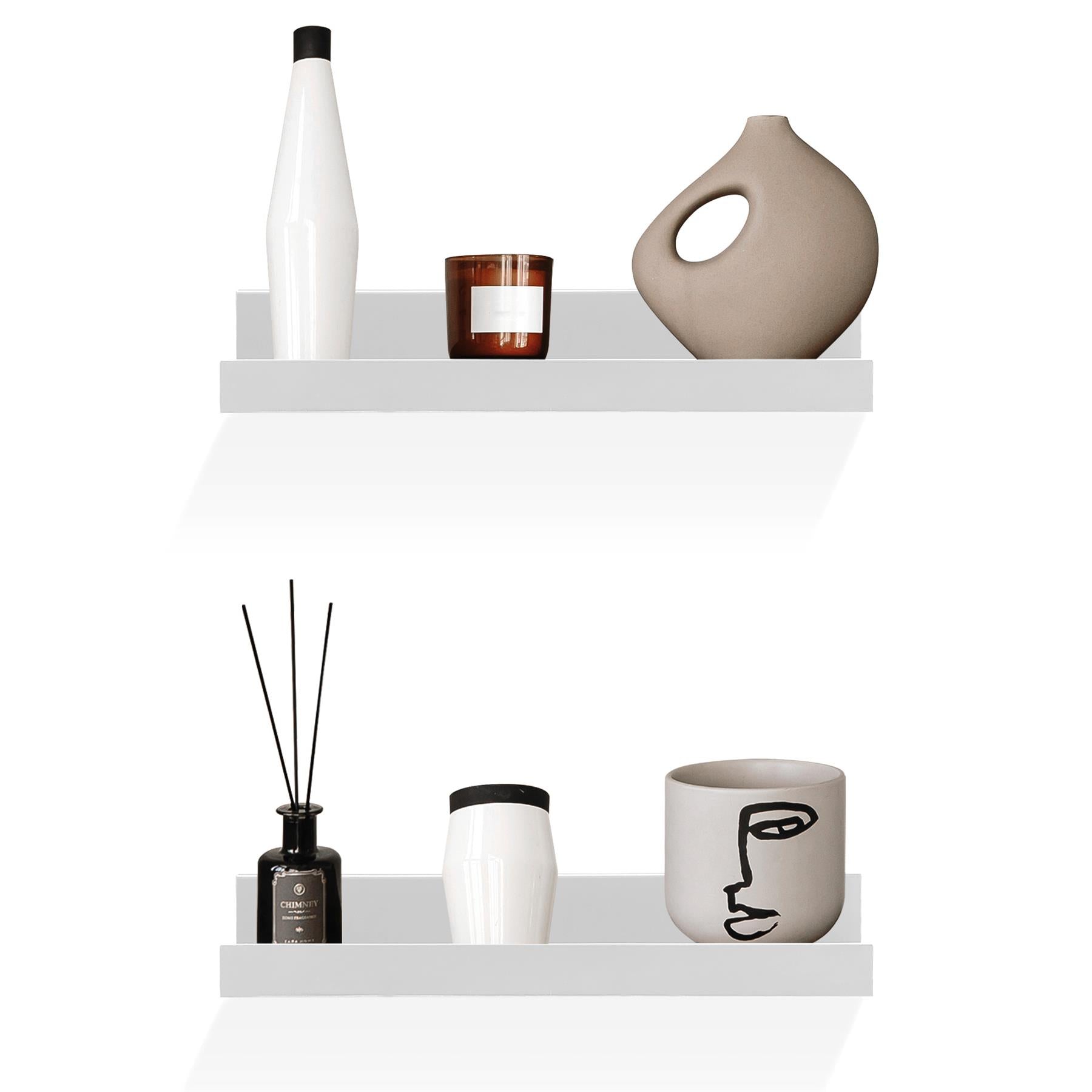 A white shelf with two levels, each holding various items. The top shelf has a white bottle, a brown candle, and a beige vase. The bottom shelf has a black bottle, a white vase, and a white cup with a face design. - The Magic Toy Shop