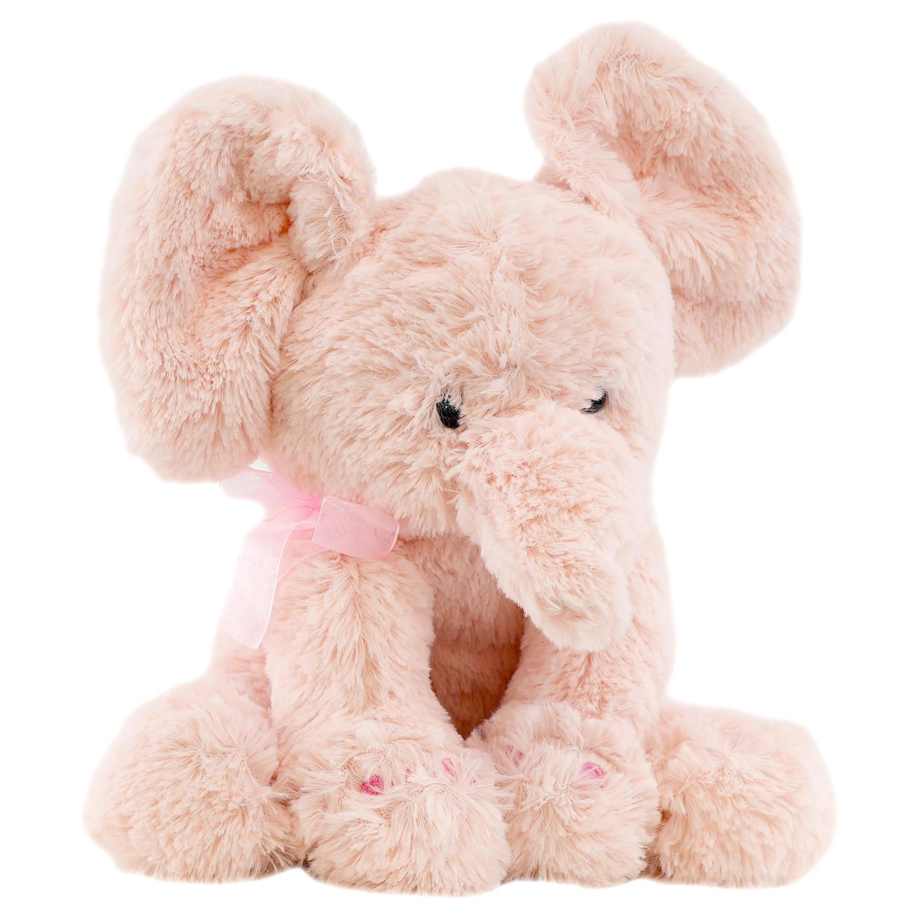 A plush stuffed toy of a pink elephant is seated, featuring large ears and a pink ribbon.