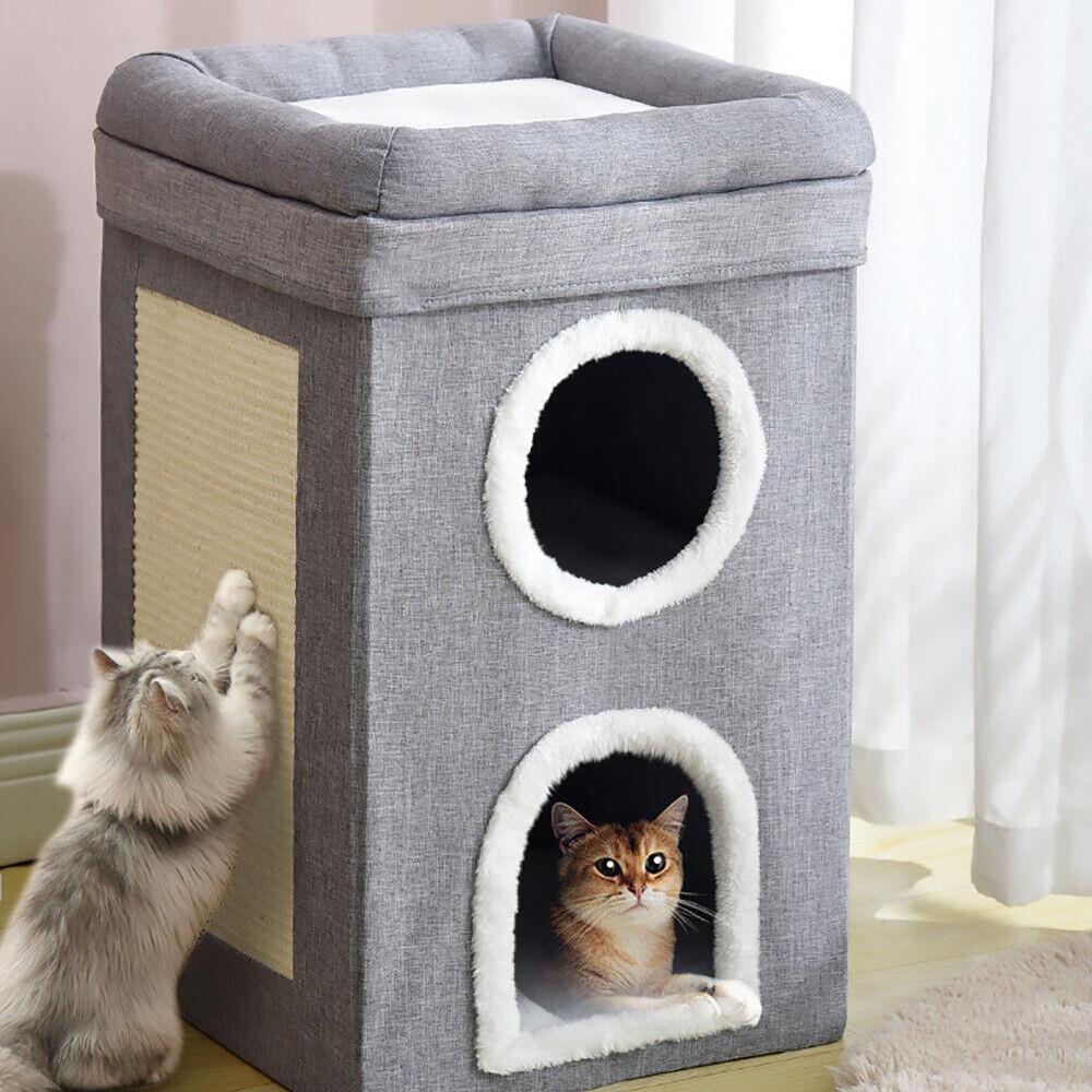 A cat plays with a cat tower, a two-story grey structure with a scratching post and two round holes for peering out. The top has a soft cushion for lounging. - The Magic Toy Shop