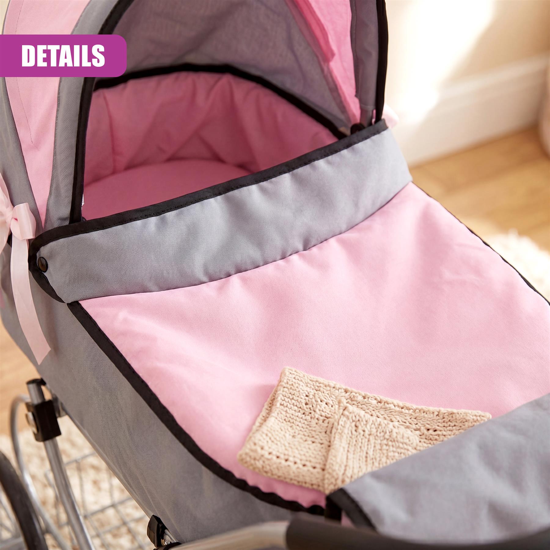 Pink and gray baby pram liner details with a beige knitted blanket visible inside the carriage bed.