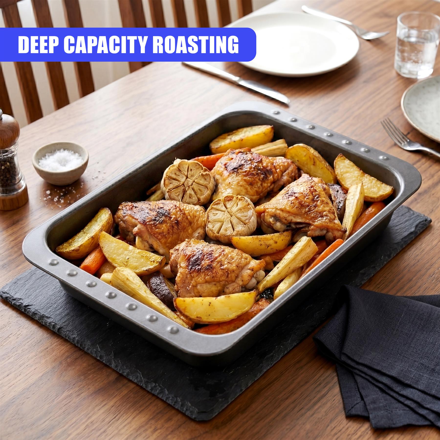 Roasting pan filled with roasted chicken, potatoes, carrots, and lemon slices on a black board.