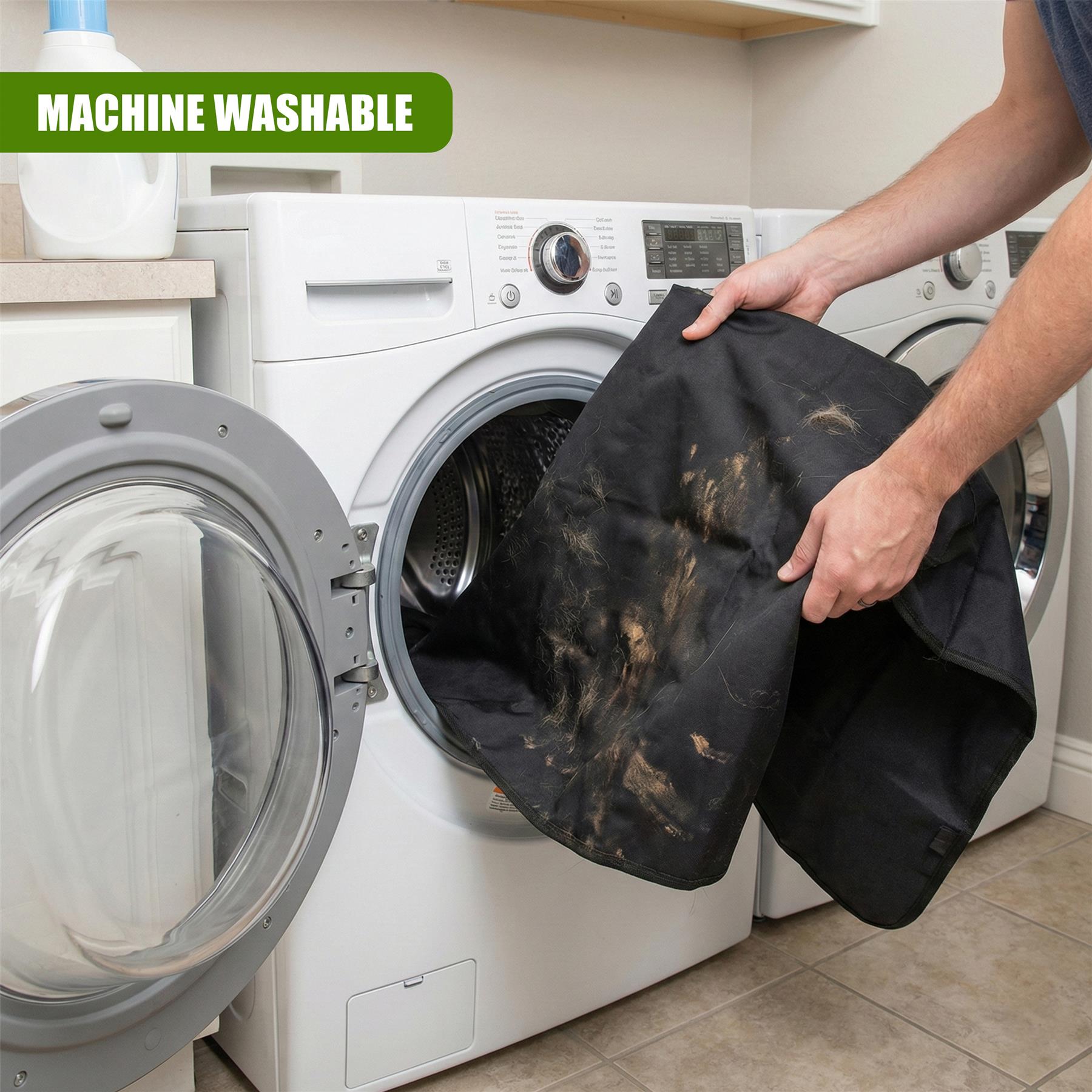 A person holding a black, waterproof cover with dirt and hair on it, in front of a washing machine. The cover has a few tears and is being held up to show the dirt and hair on it. - The Magic Toy Shop