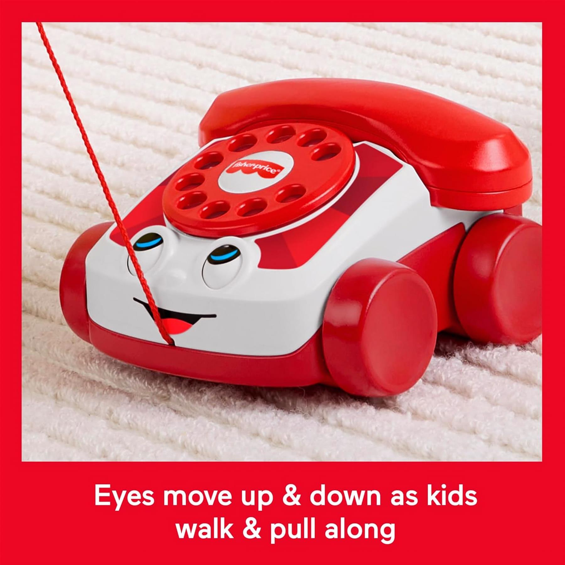 Red and white toy phone replica featuring a rotary dial and two moving eyes.