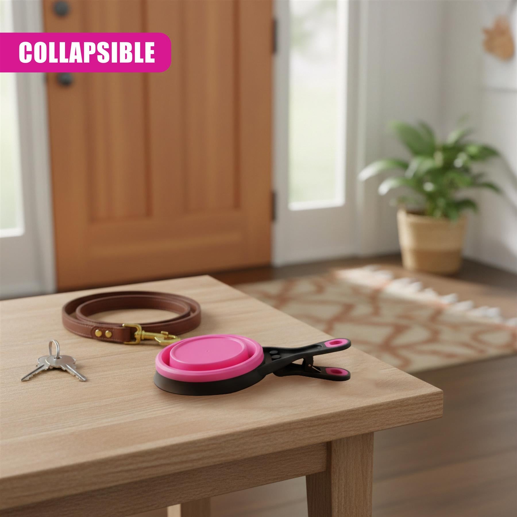 Collapsible pink and black pet scoop, keys, and leather collar displayed on a wooden table surface.