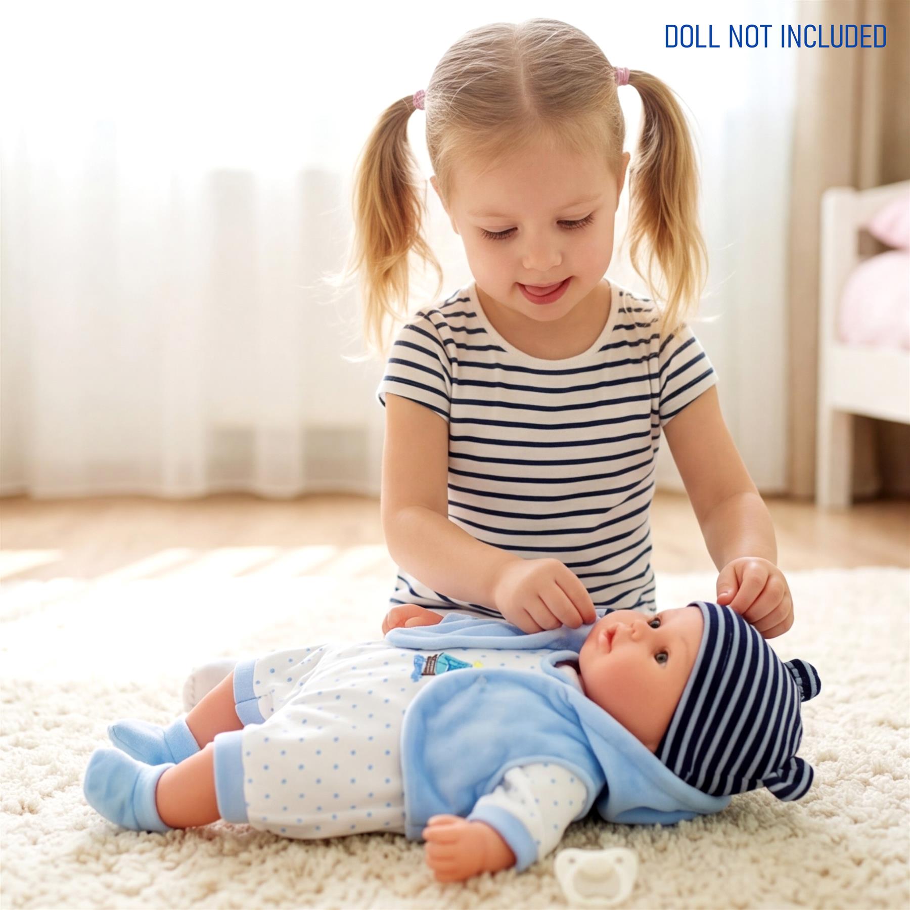 Child dressing a doll on a light carpet. The doll wears blue patterned clothing and a striped hat.