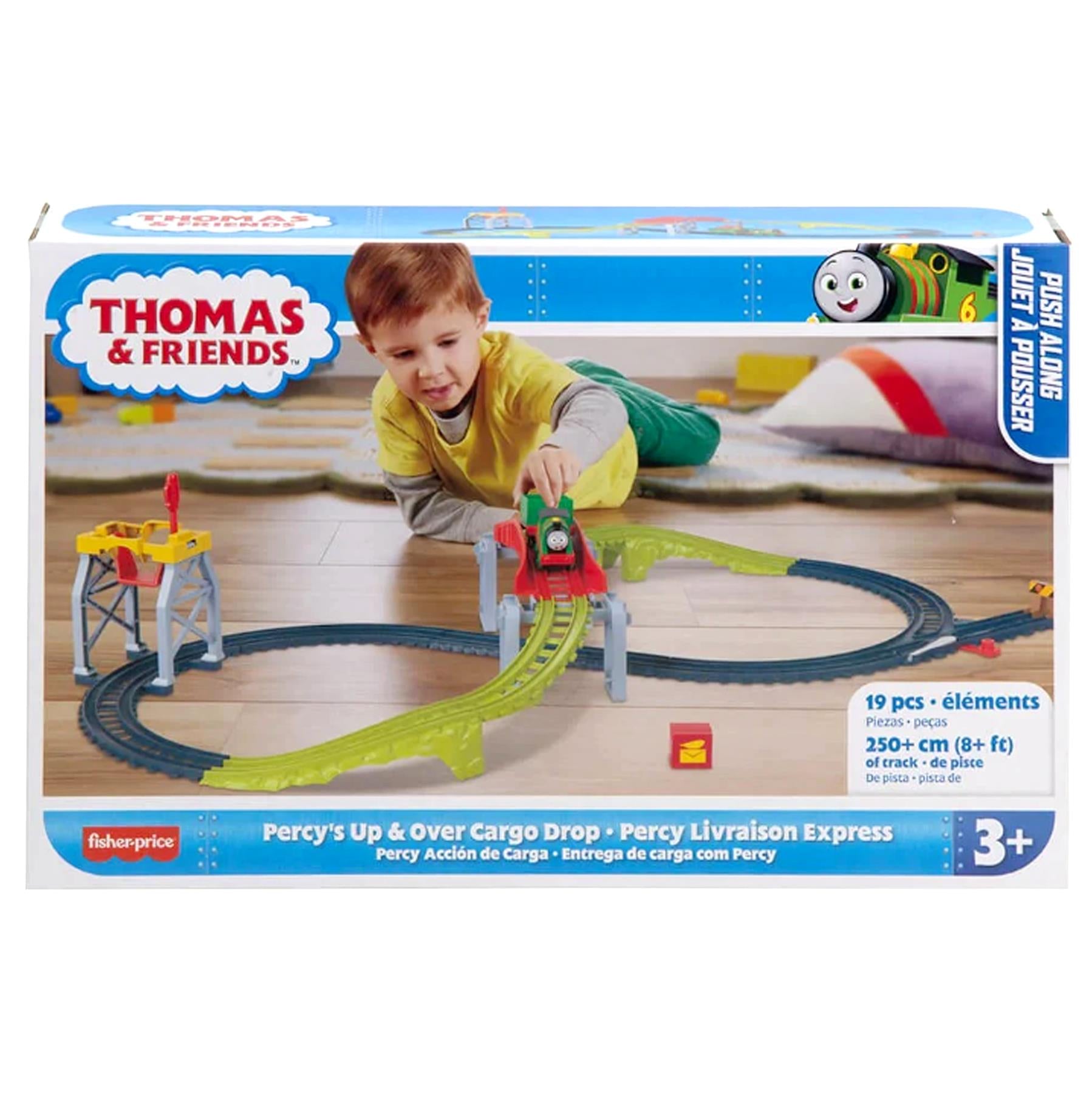 A child plays with a Thomas & Friends train track set, featuring Percy and curved green tracks.