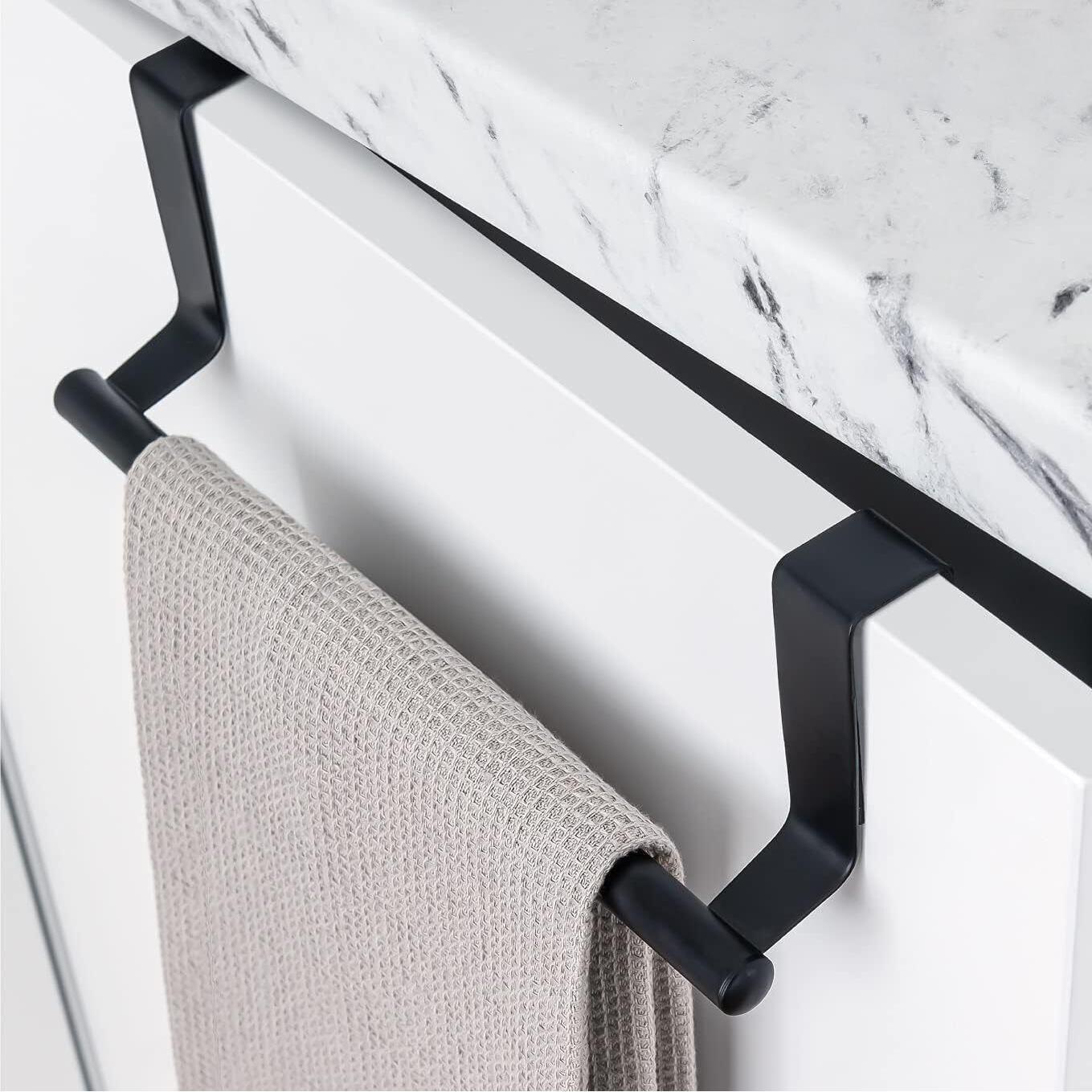A black metal towel rack with a towel hanging from it, attached to a white marble countertop. - The Magic Toy Shop