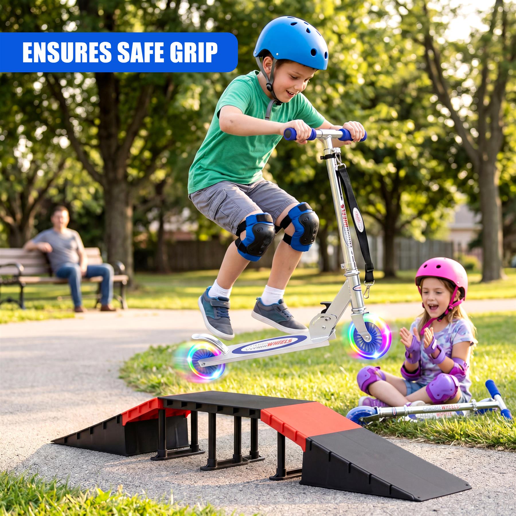 A boy rides a blue scooter while a girl watches nearby near a red and black ramp.
