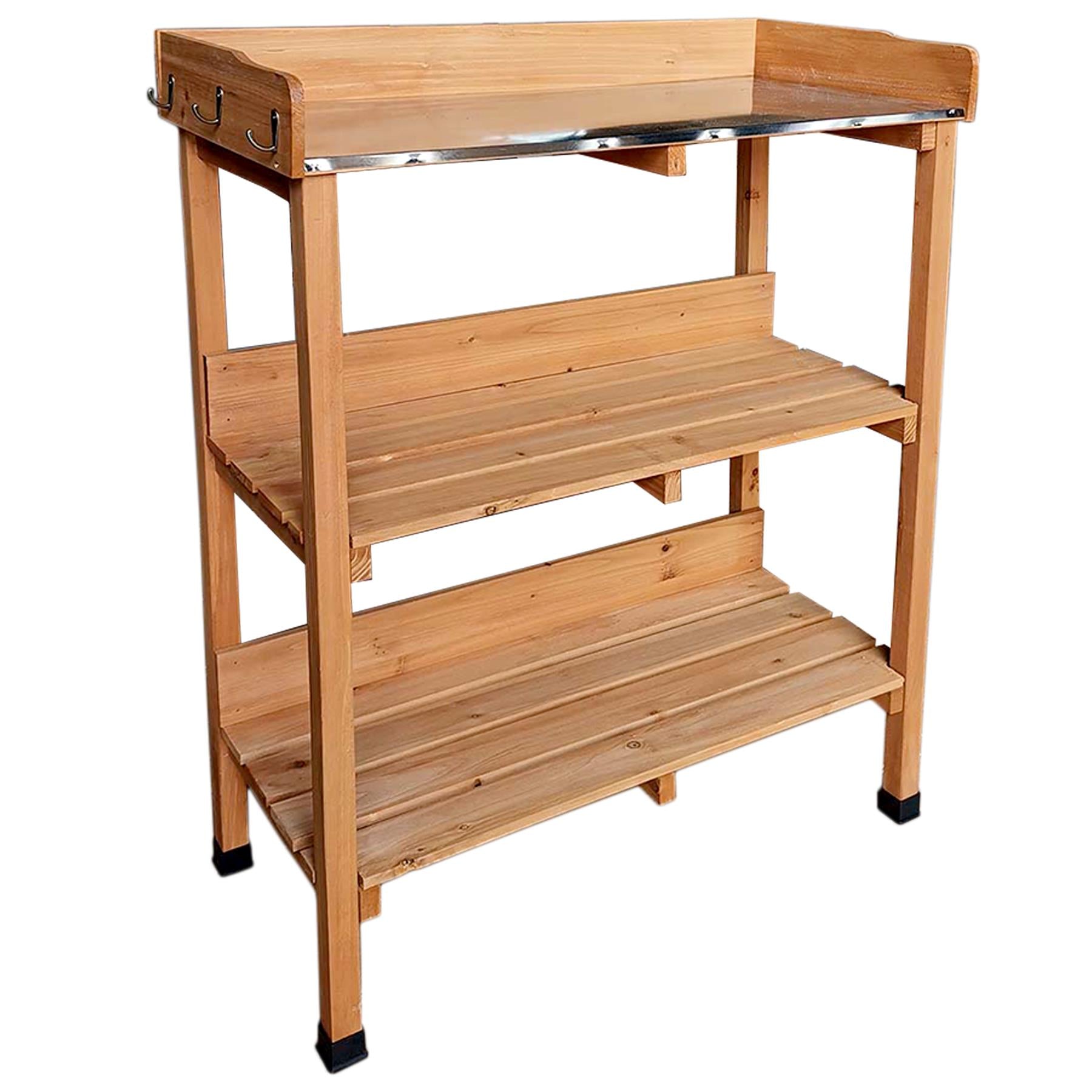 A wooden shelving unit with multiple shelves, a metal shelf at the top, and a small storage compartment. - The Magic Toy Shop