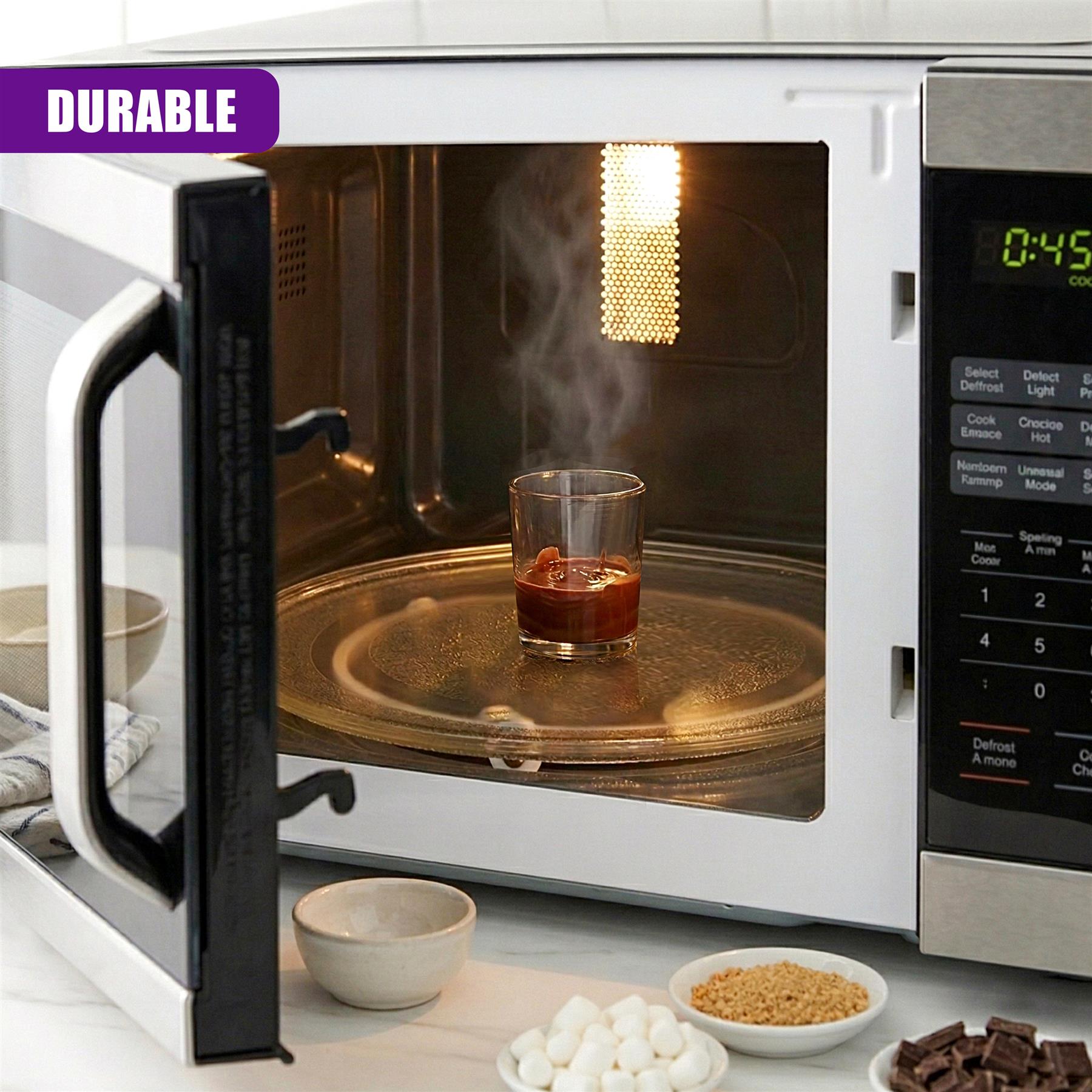 An open microwave displays a glass containing red liquid, positioned near various dessert ingredients.