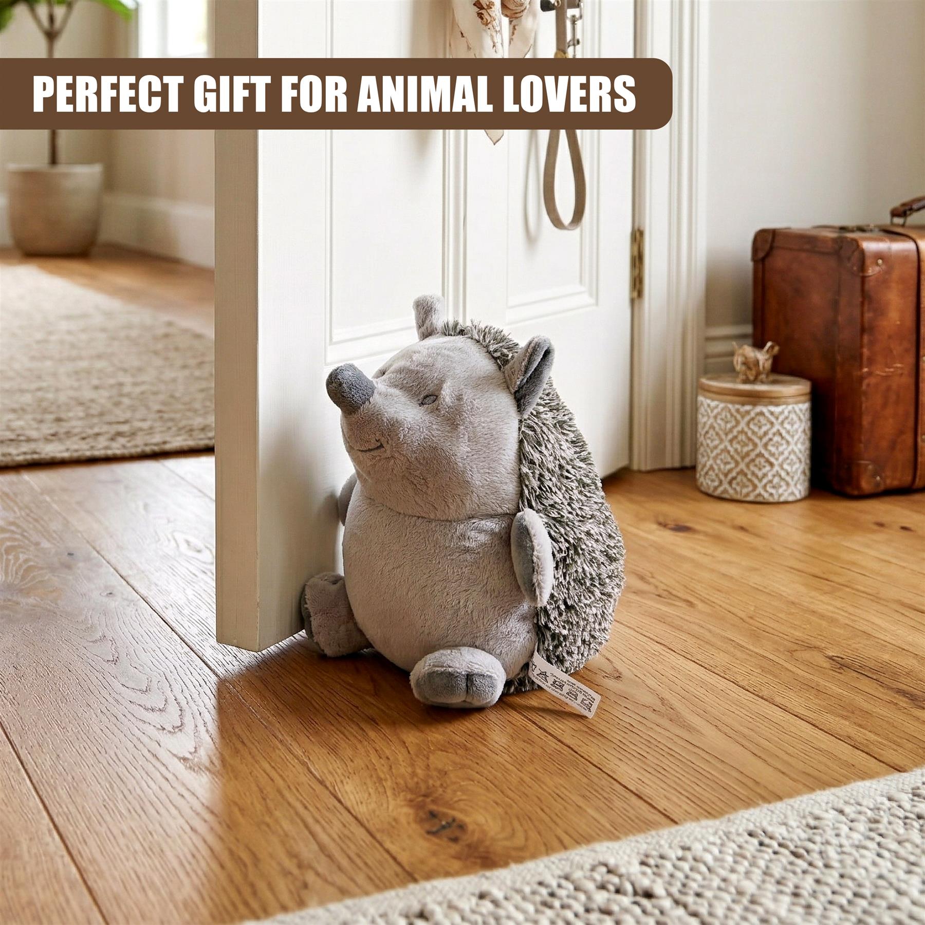 A plush hedgehog door stopper rests on a hardwood floor against a white doorway.