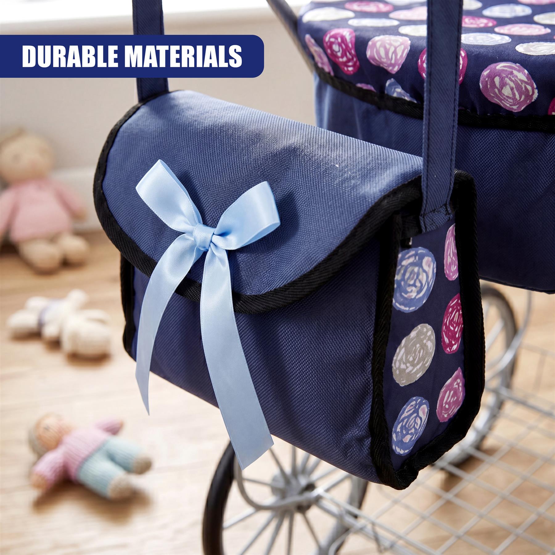 Blue canvas tote bag featuring a bow and contrasting circular patterned patches attached to the pram.