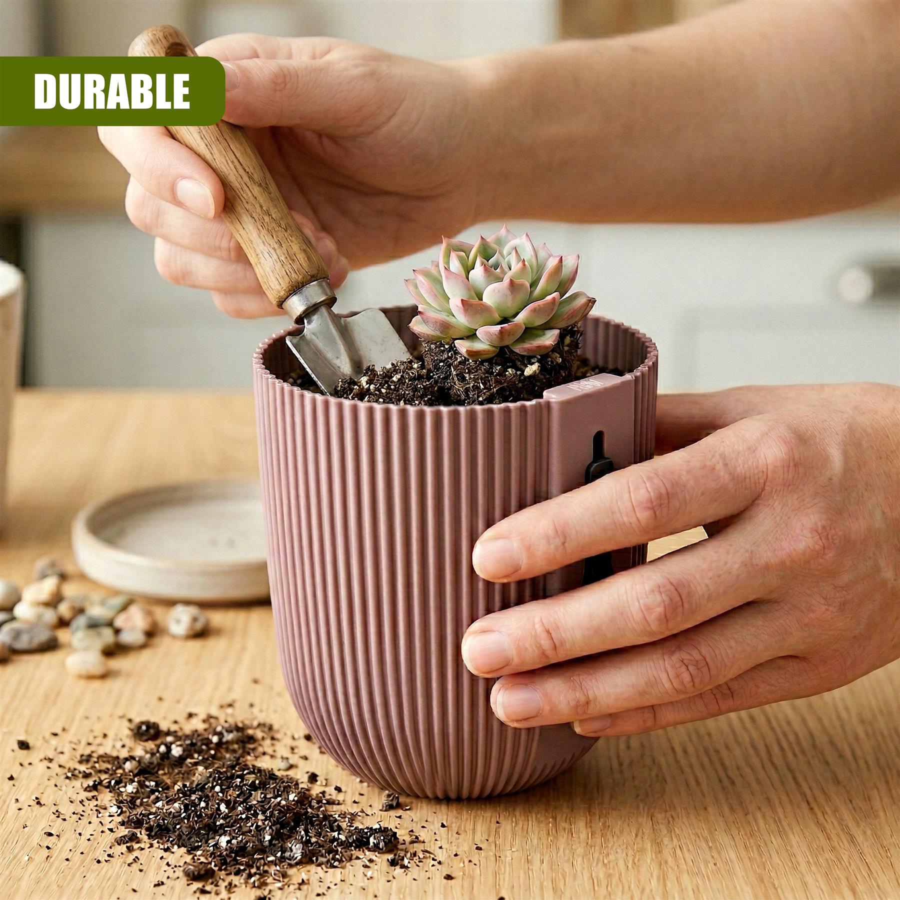 Hands pot a succulent plant into a vertical, ribbed pink planter using a small garden trowel.