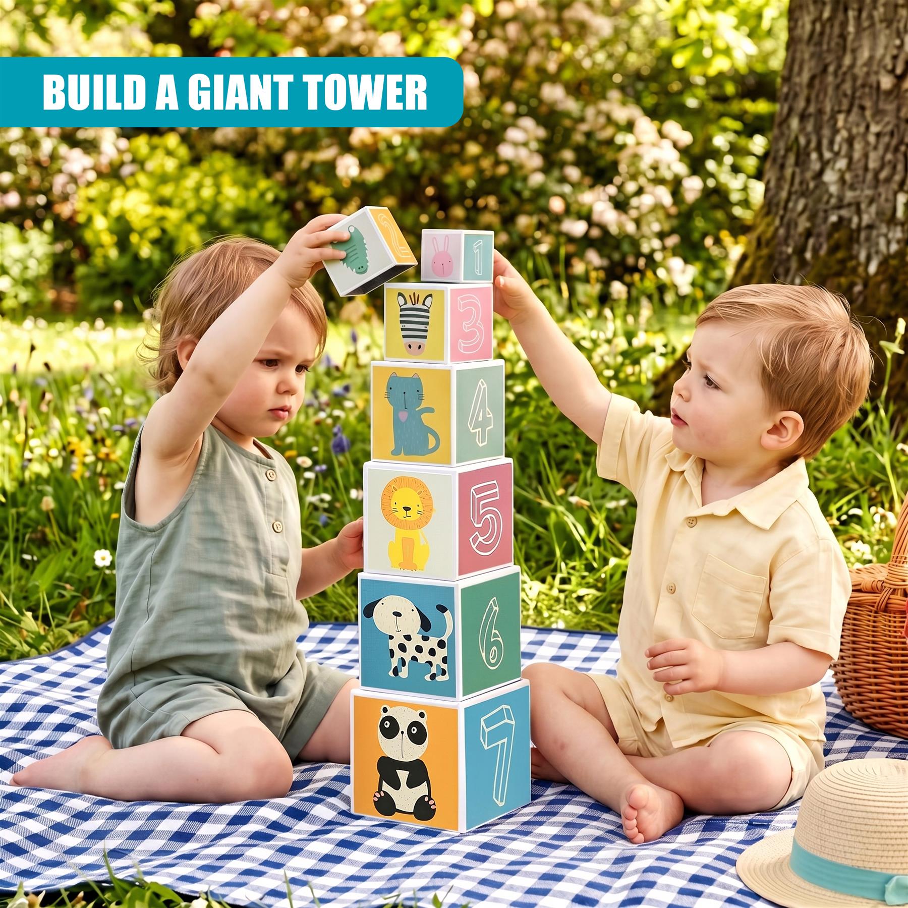 Two boys stack a multi-colored, numbered block cube tower outdoors on a blanket.