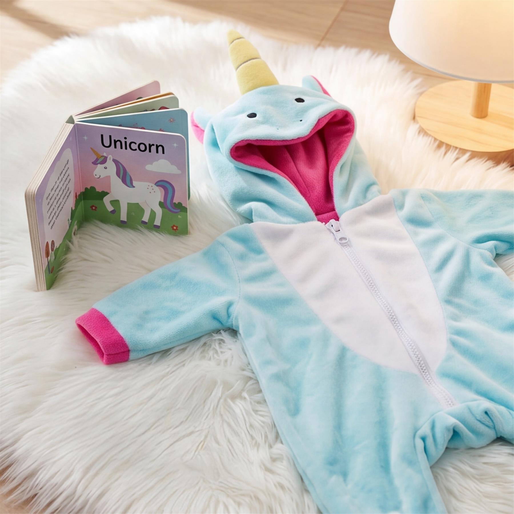 Light blue unicorn hooded doll outfit displayed next to a rainbow and unicorn book.
