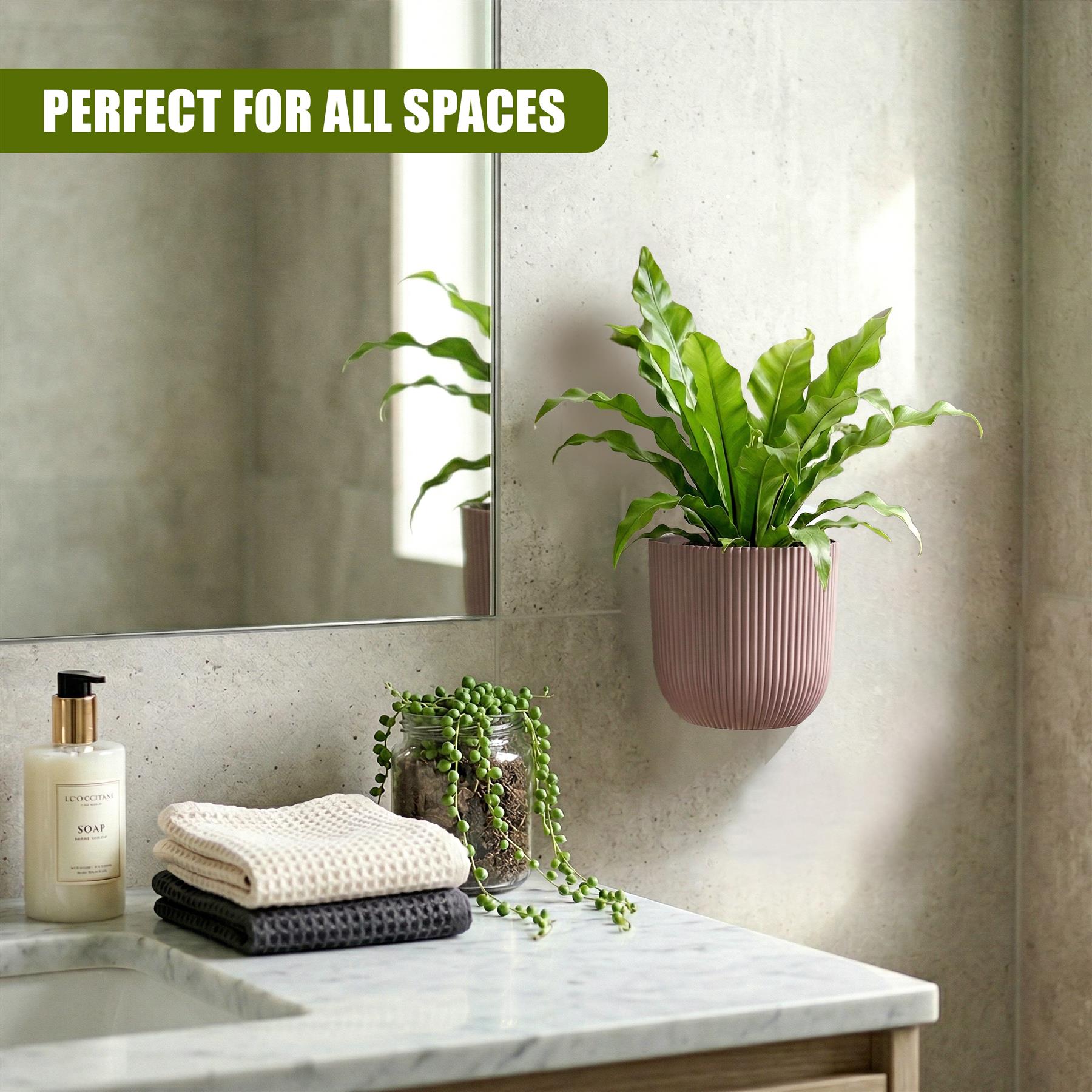 Wall planter with greenery displayed above toiletries and folded cream towels.