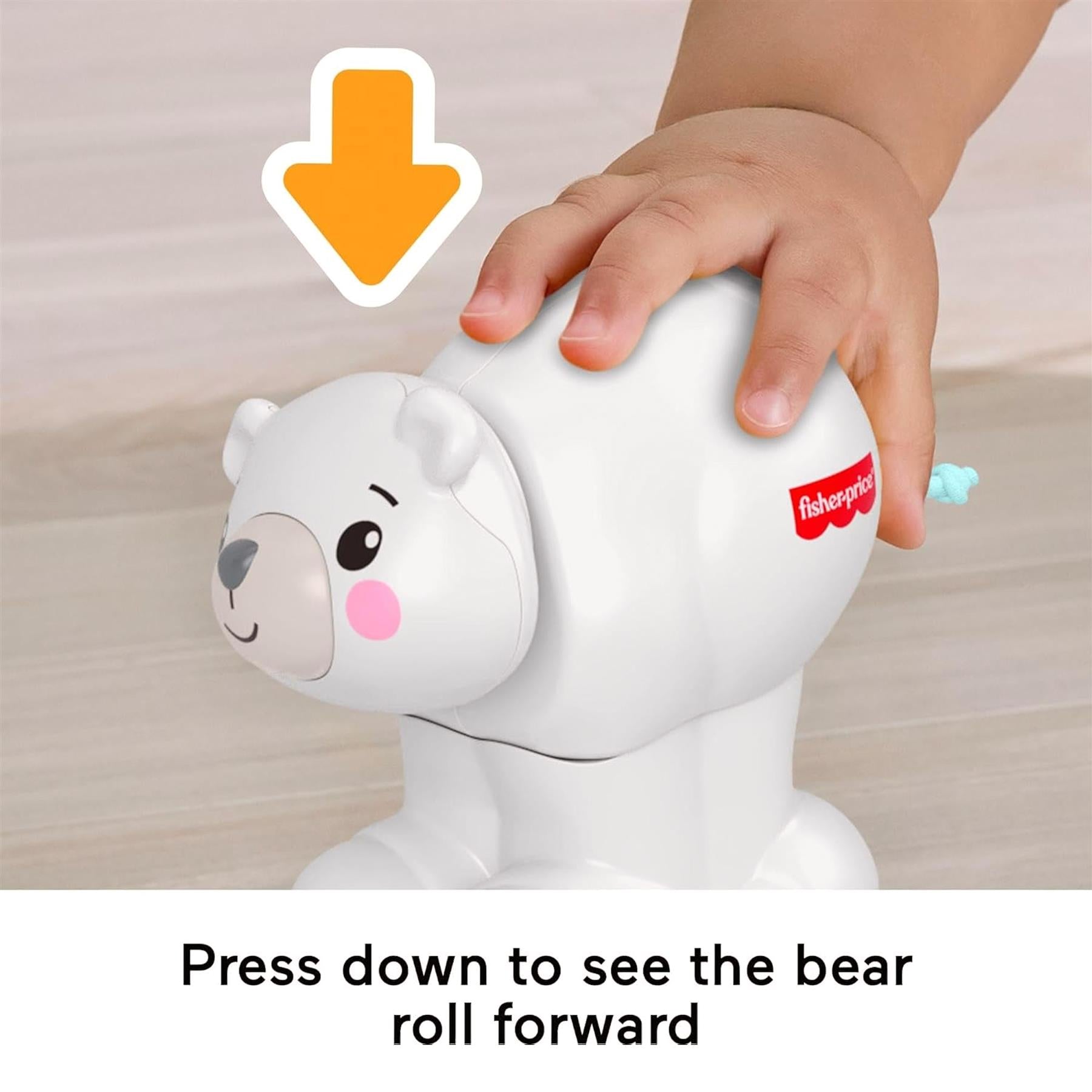 A hand presses down on the top of the white polar bear toy, causing the bear to move forward.
