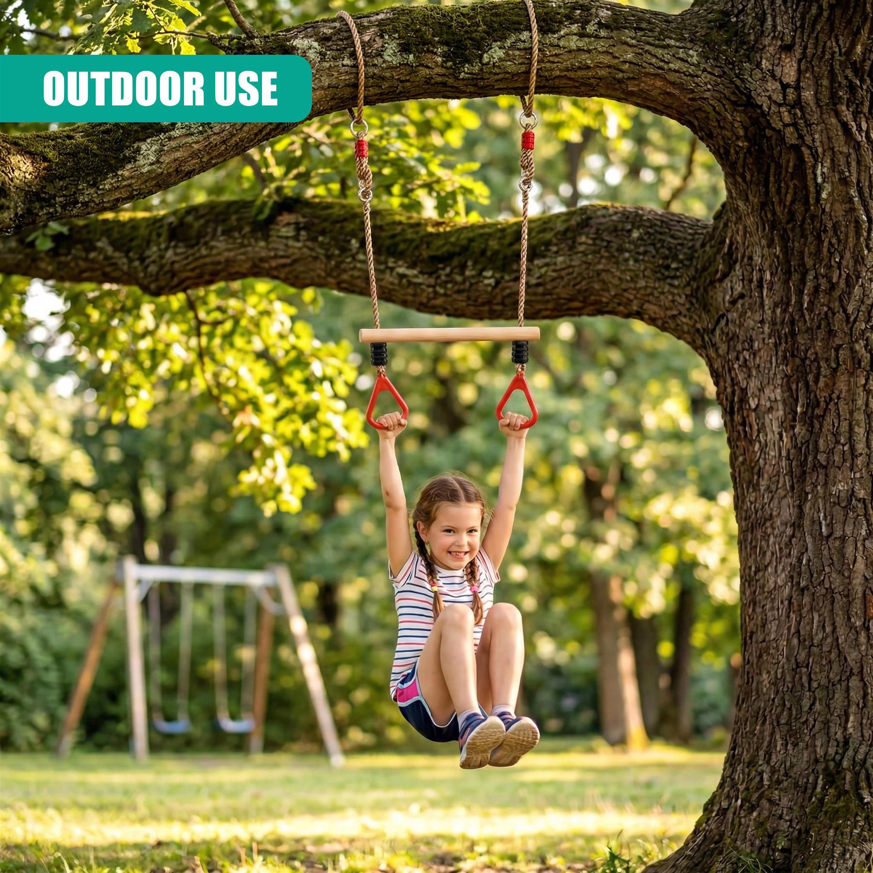 Girl hangs from a rope swing apparatus attached to a substantial tree branch in a park.