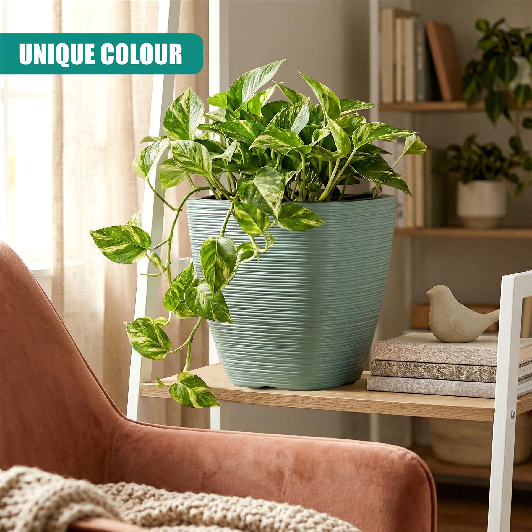 Ribbed, square, aqua planter pot holding healthy green foliage on a wooden surface.