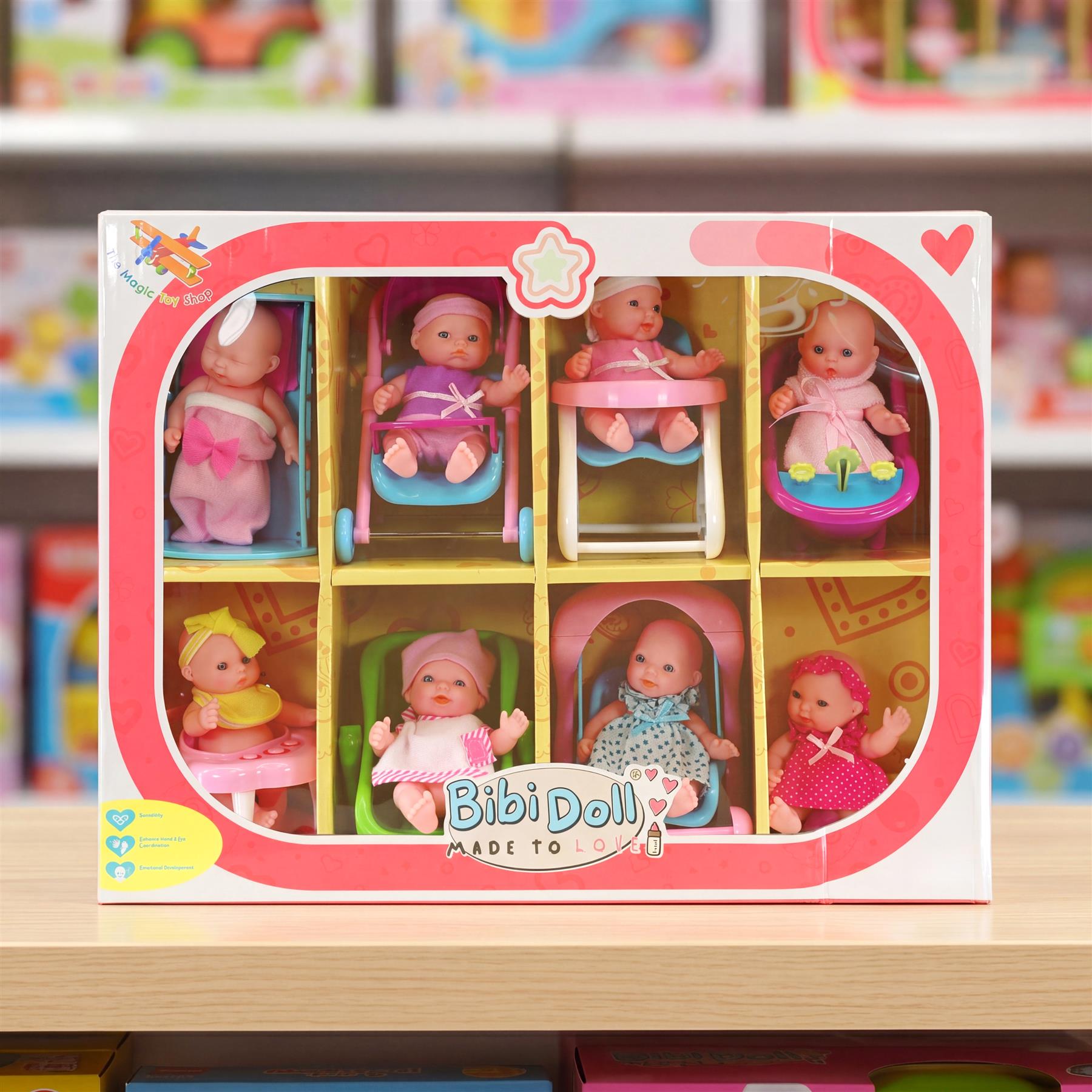 A box containing eight miniature baby dolls dressed in various outfits and accessories.