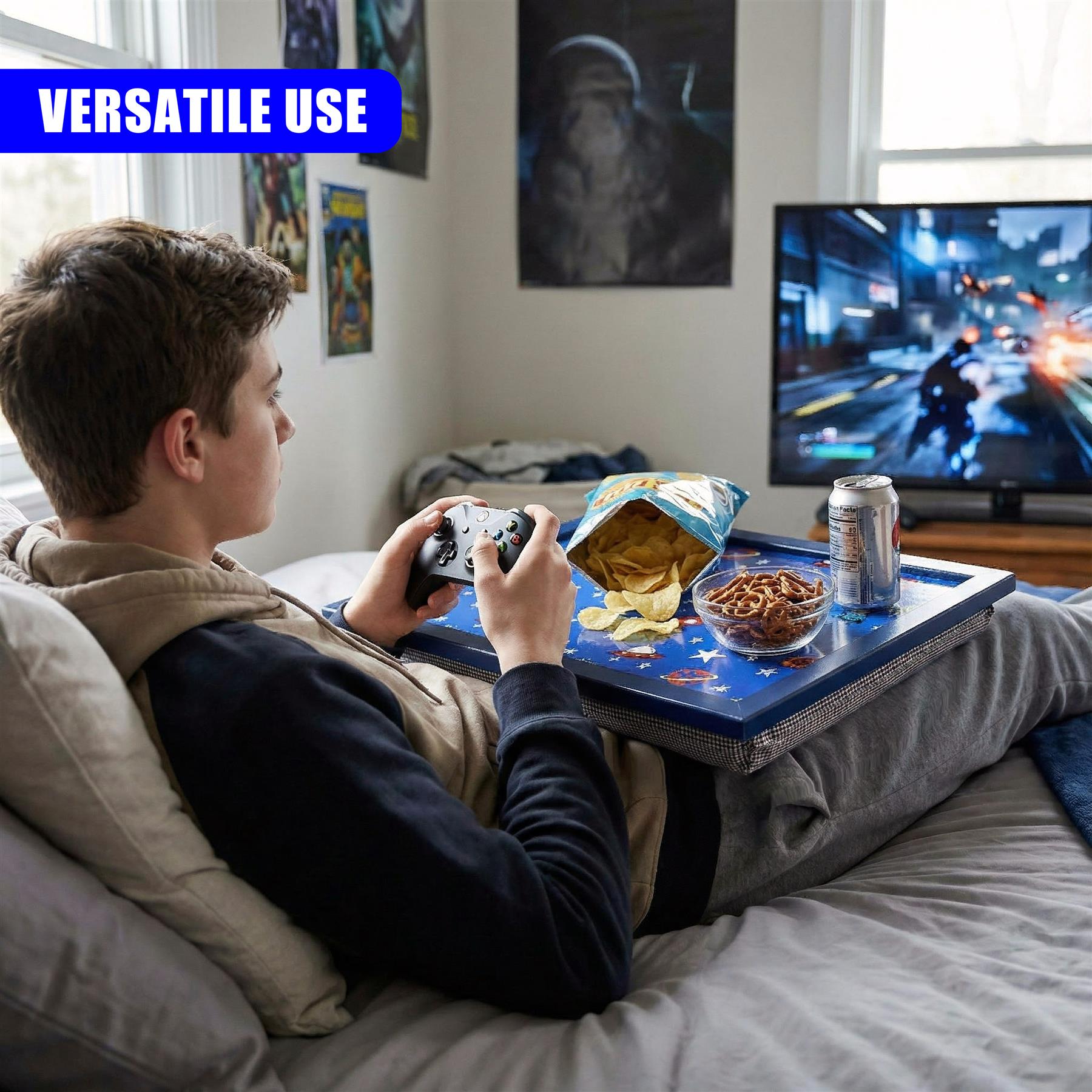 A person uses a lap tray on a couch while gaming, holding a controller and snacks.
