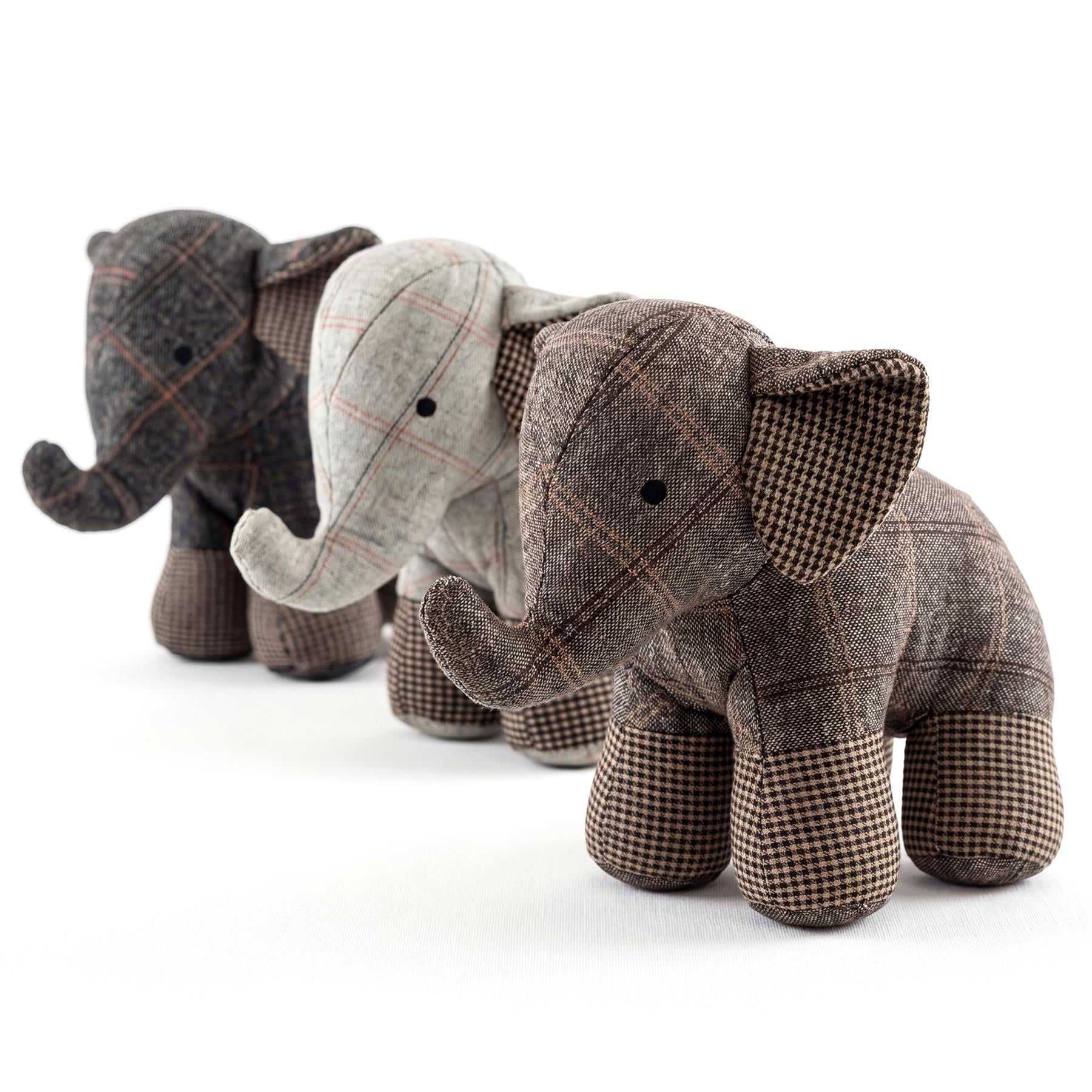 Four plaid fabric elephants arranged in a row, standing on a plain white background.