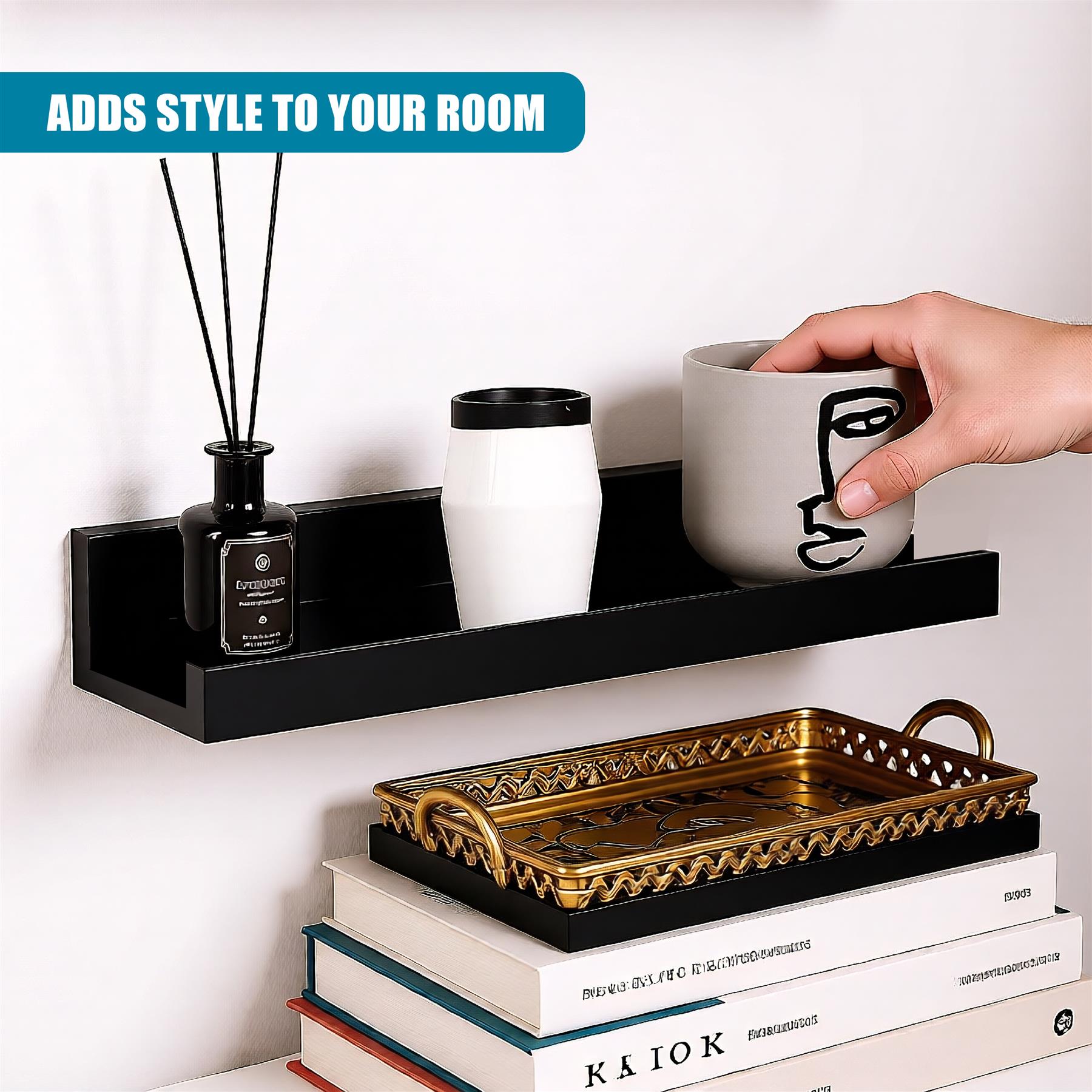 A floating shelf made of black wood, holding a small bottle of reed diffuser, a white vase, and a coffee mug. The shelf is mounted on a white wall, and a hand is reaching in to grab the mug. Below the shelf, a stack of books and a decorative tray are placed on a white shelf. - The Magic Toy Shop