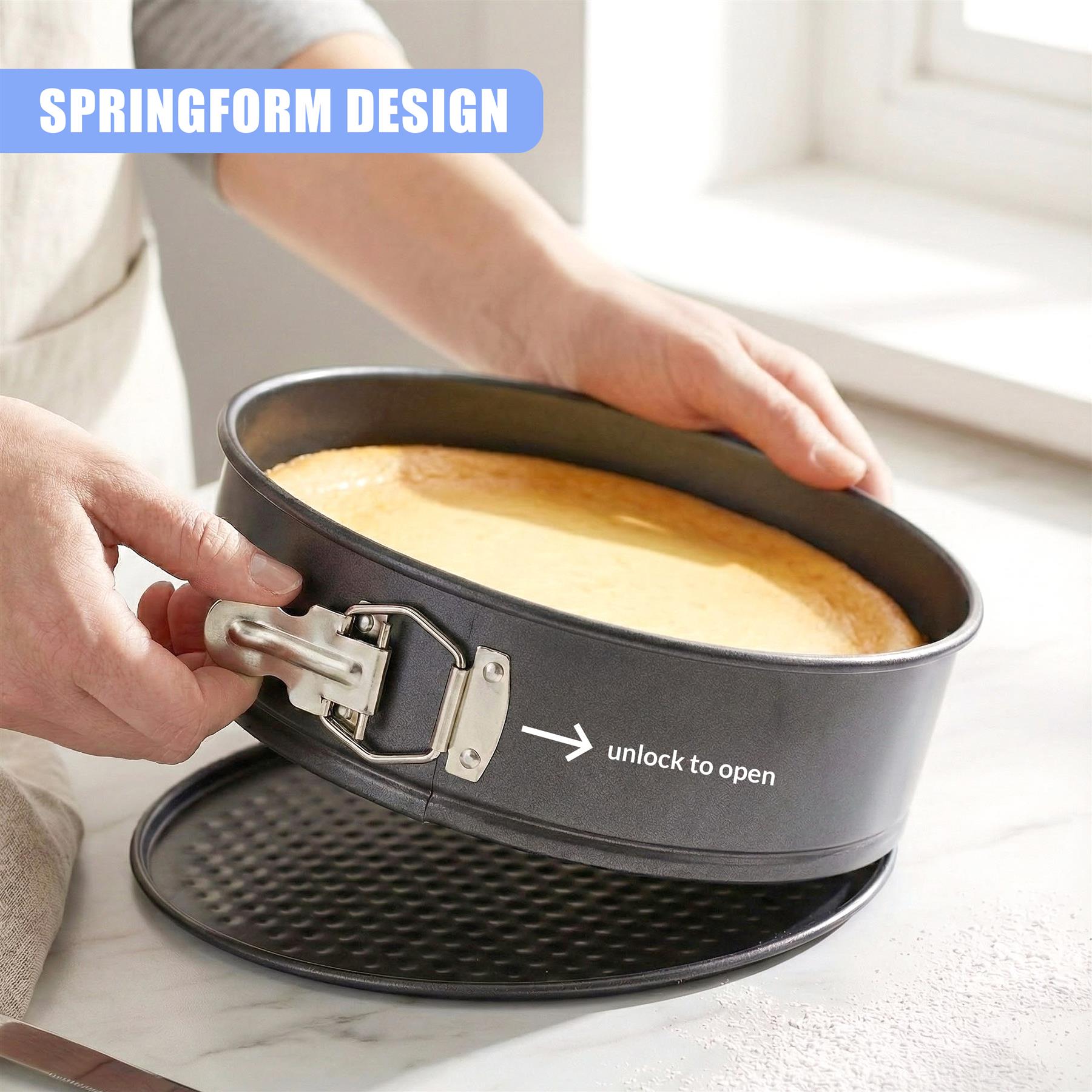 A metal springform cake pan with a visible latch mechanism is being held above a fitted baking pan.