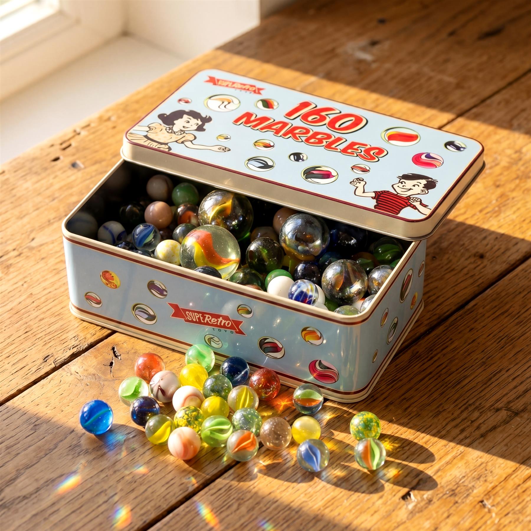 Open metal box containing many colorful glass marbles, with additional marbles scattered on wood.