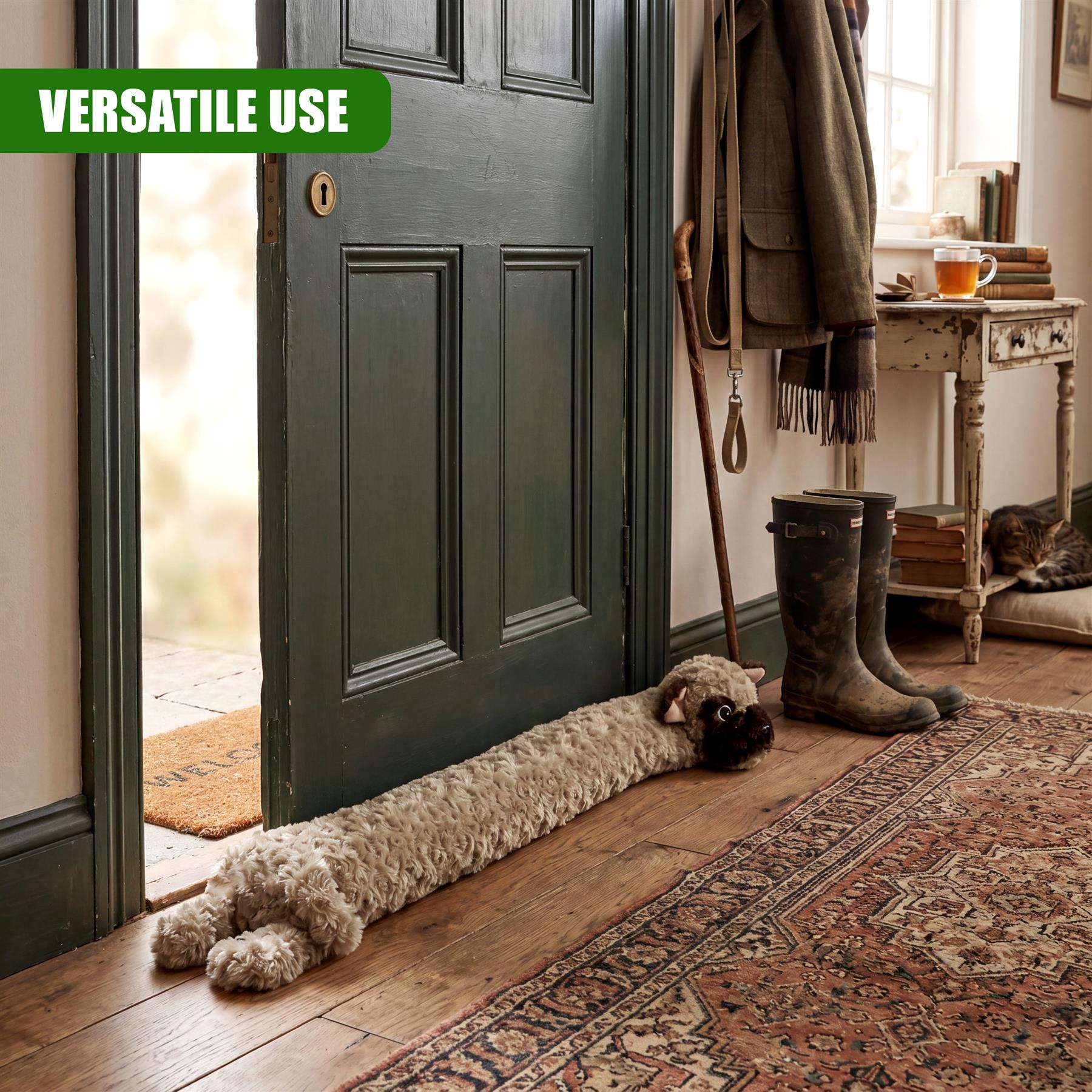 A plush dog draught excluder rests on a patterned rug at the base of a dark green door.
