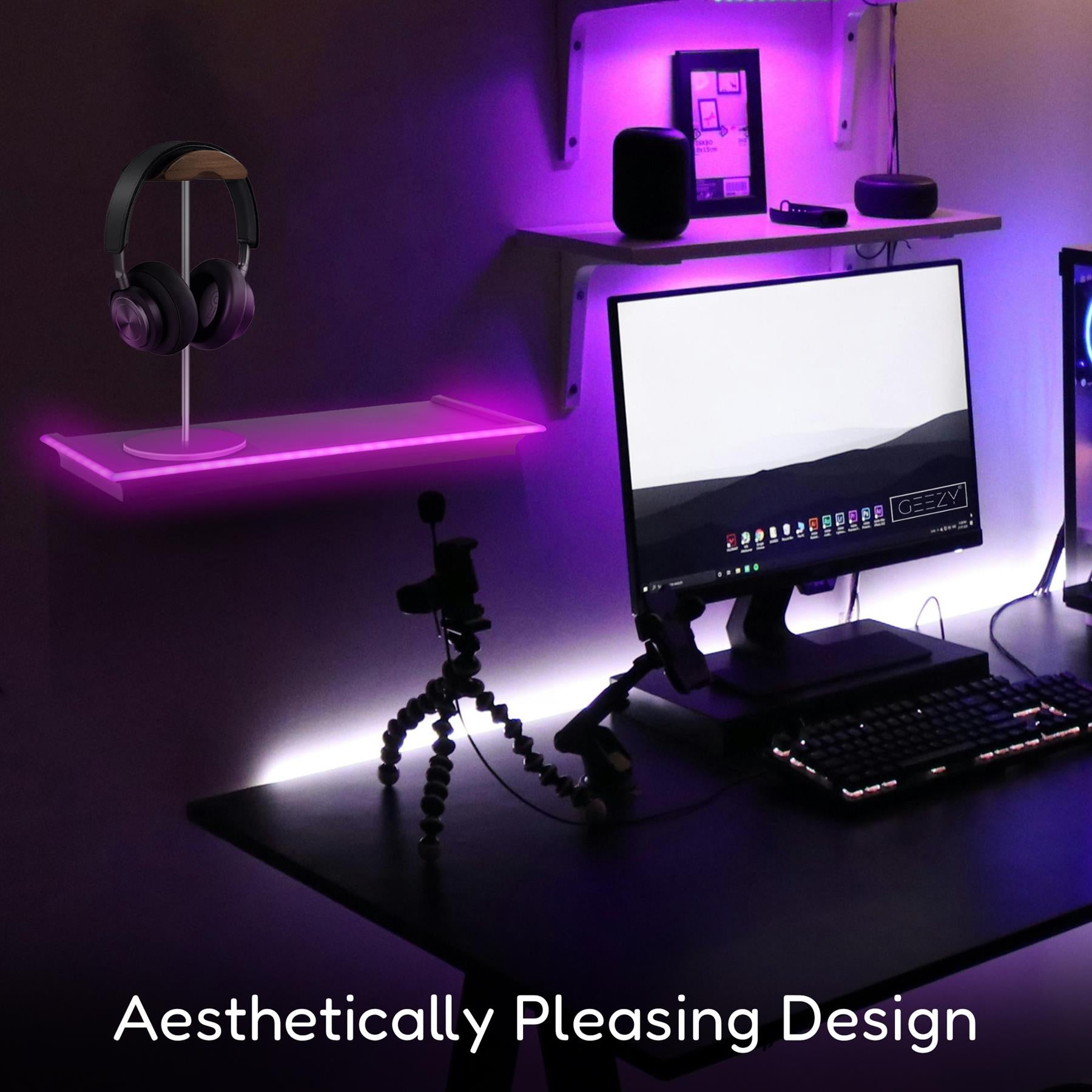 A modern workspace featuring GEEZY black floating shelves illuminated with vibrant neon purple lights. A sleek headphone stand is displayed on one shelf, creating an organized and visually appealing setup. A computer monitor and keyboard are visible on the desk, enhancing the aesthetic ambiance. Ideal for gamers and tech enthusiasts looking for stylish storage solutions. themagictoyshop