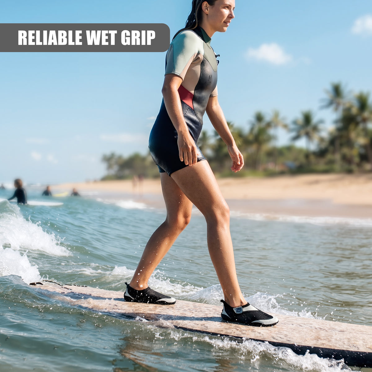 Grey GEEZY aqua shoes on a beach, a woman is paddling on a board in the water