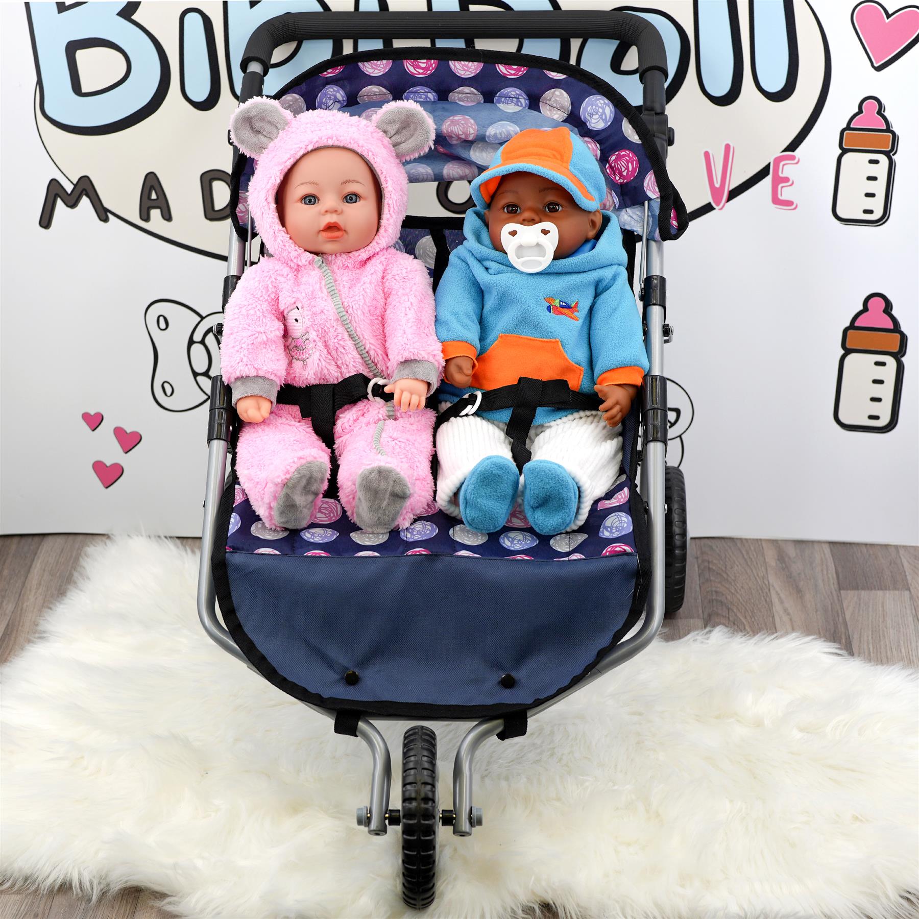A twin doll pushchair holds two dolls: one dressed in pink, and one dressed in blue.