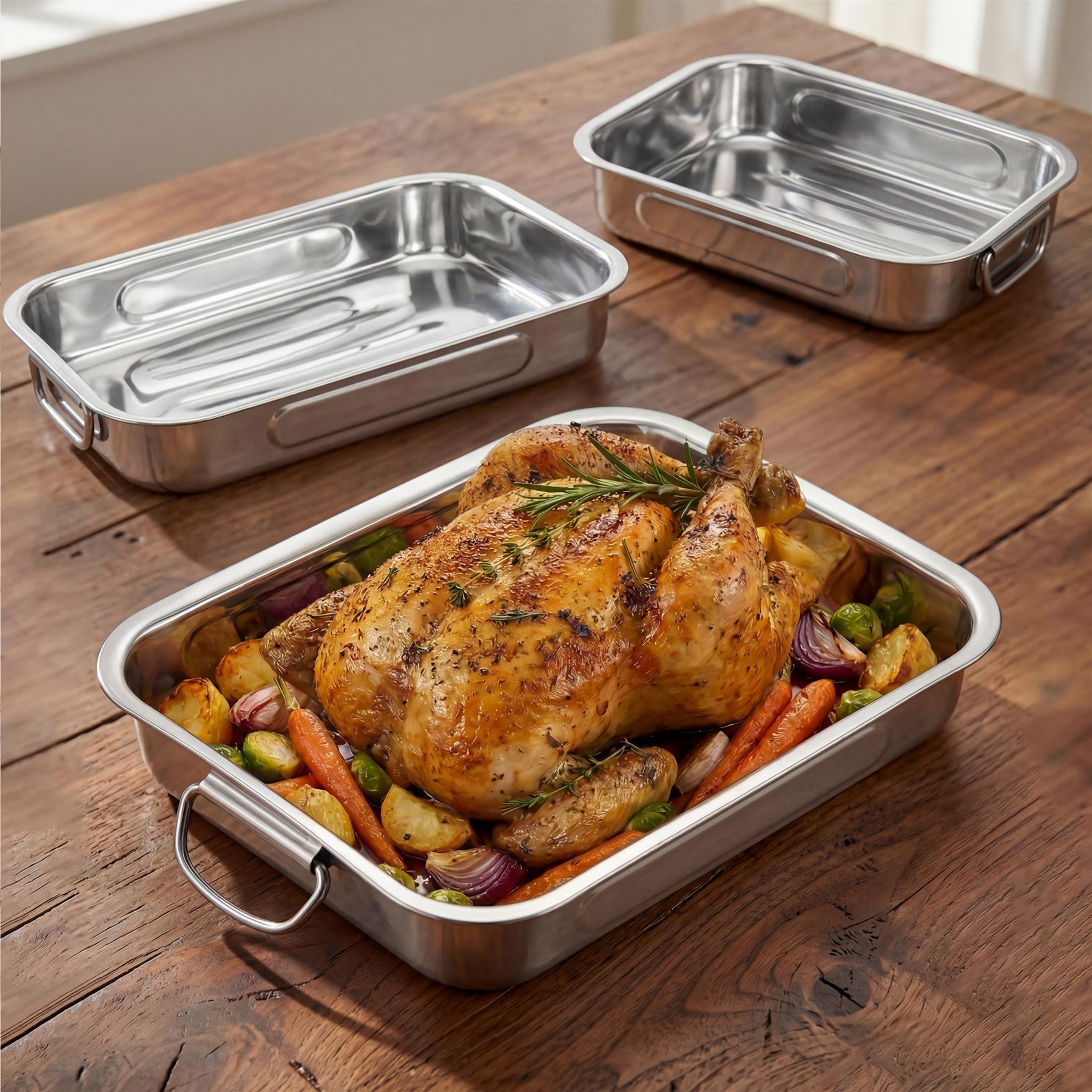 The image displays three stainless steel trays, one filled with roasted chicken and vegetables.