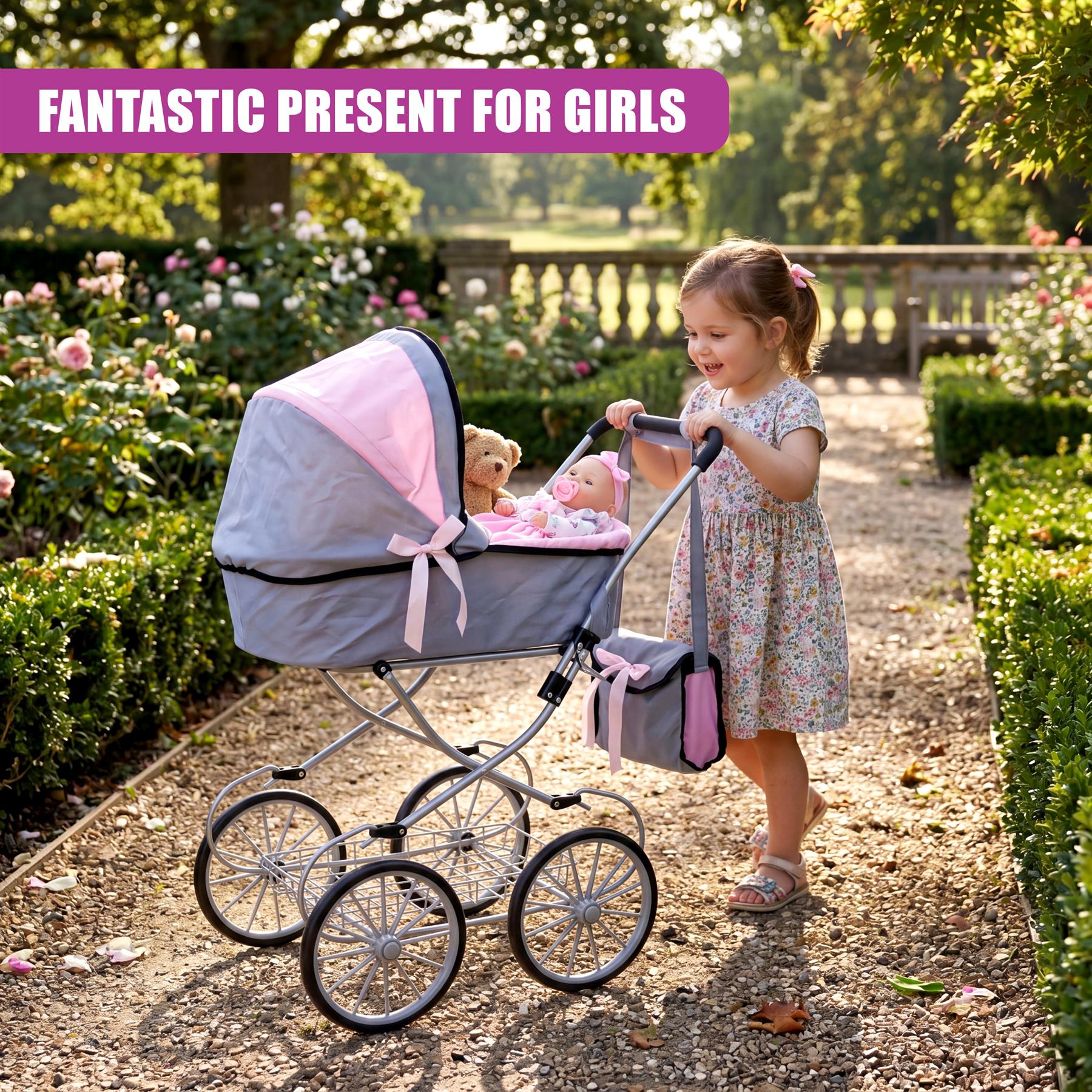 A girl stands in a garden next to a gray and pink doll pram containing miniature dolls.