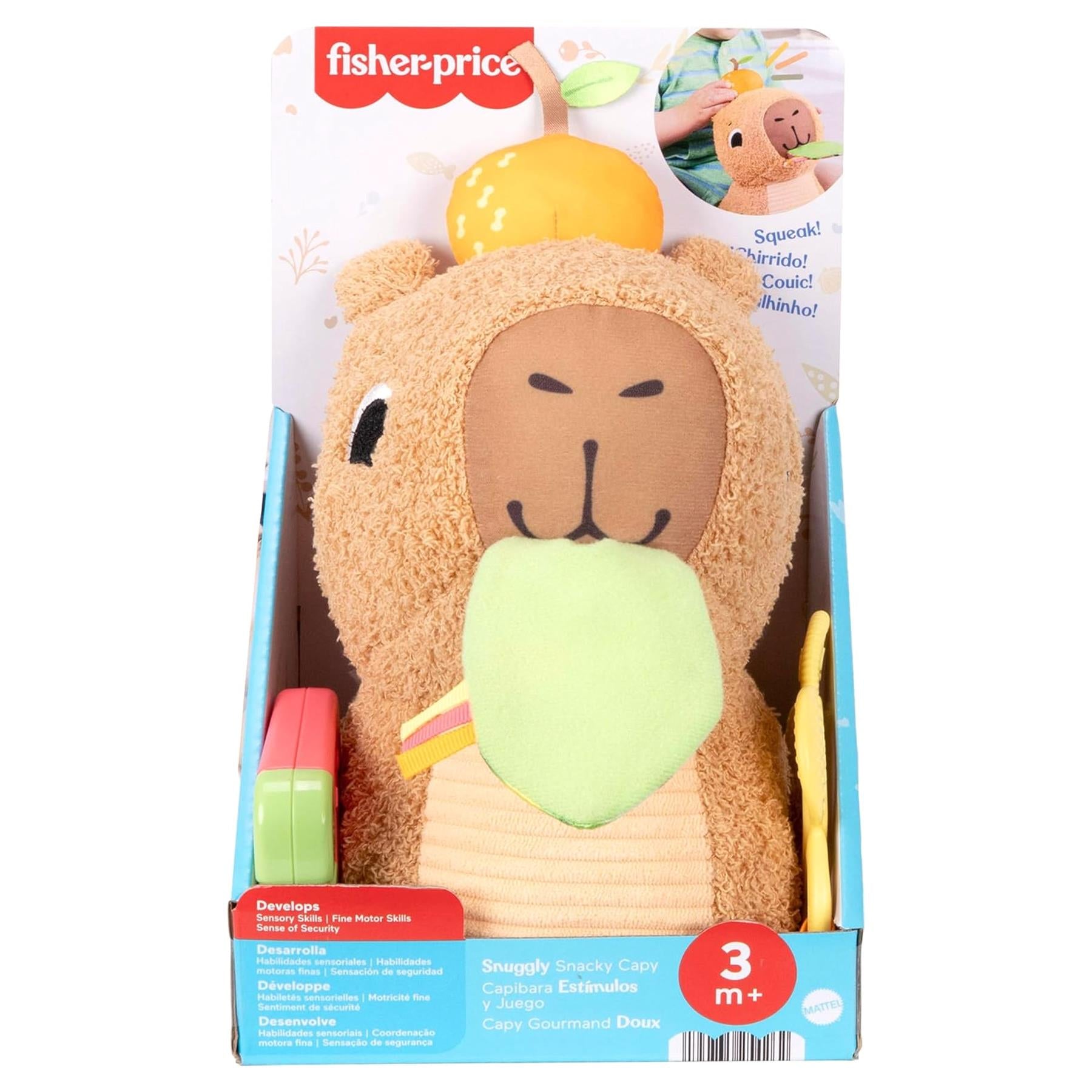 Plush capybara stuffed toy holding a green sensory object inside its branded retail packaging box.