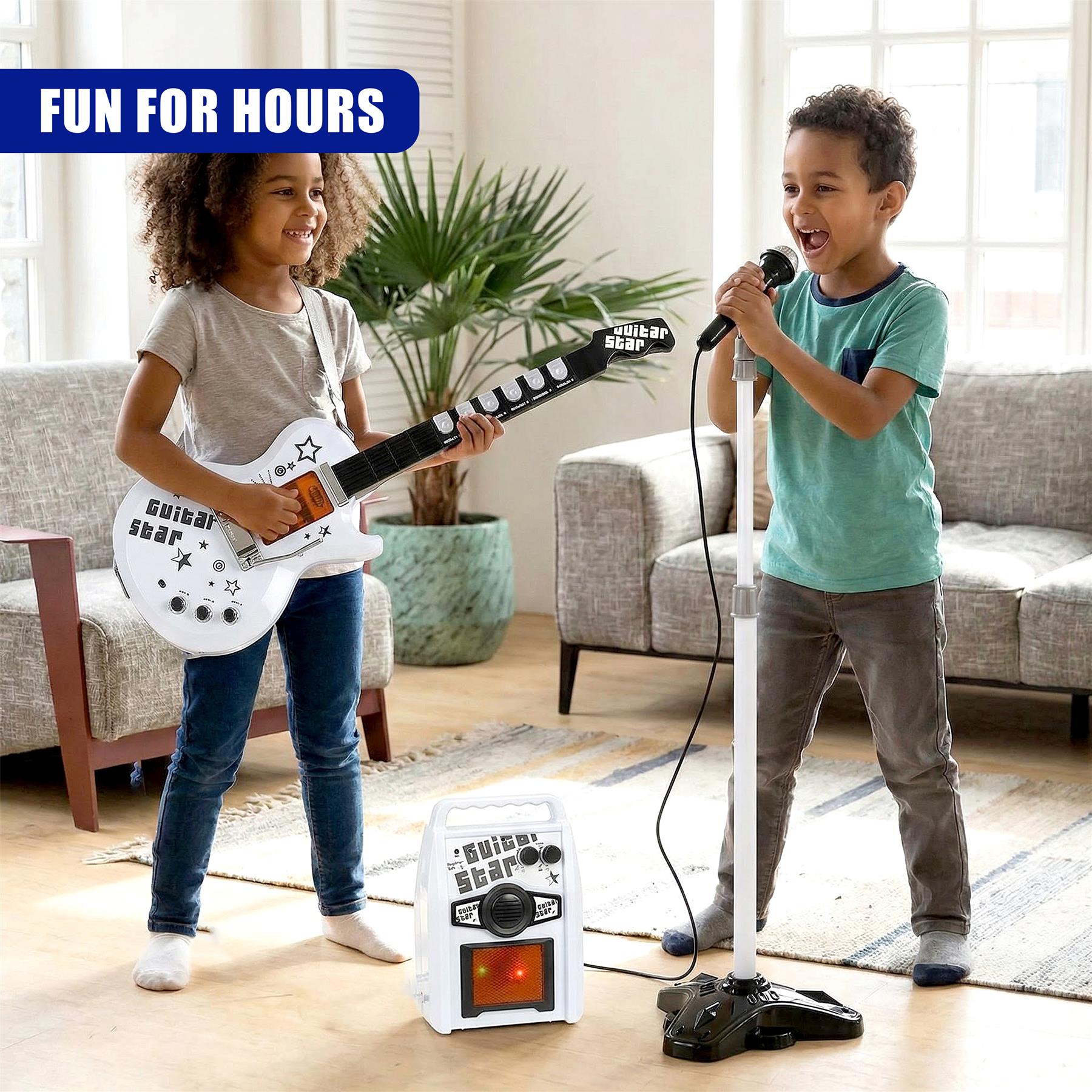 Children pose with a white electric guitar, microphone, and amplifier set indoors.
