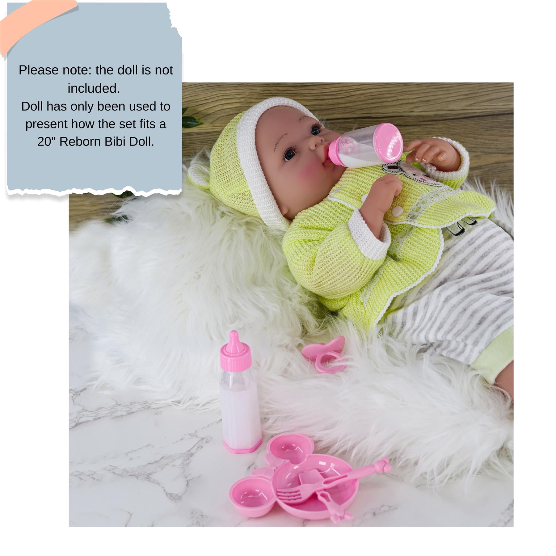 Doll wearing yellow outfit rests with a pink feeding set, including a bottle, plate, and small cup.