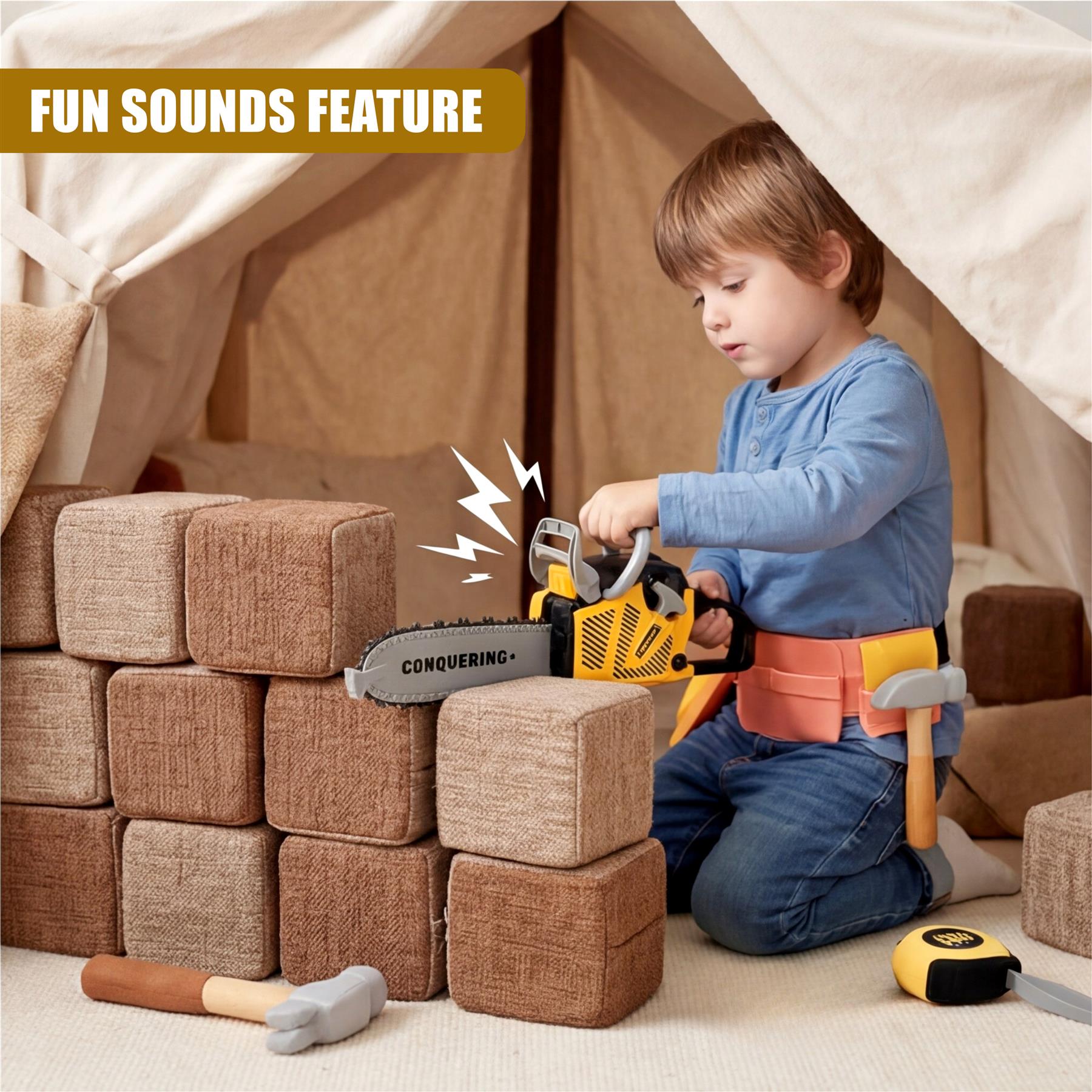 Young child operating a yellow chainsaw toy amidst stacked fabric blocks inside a play tent.