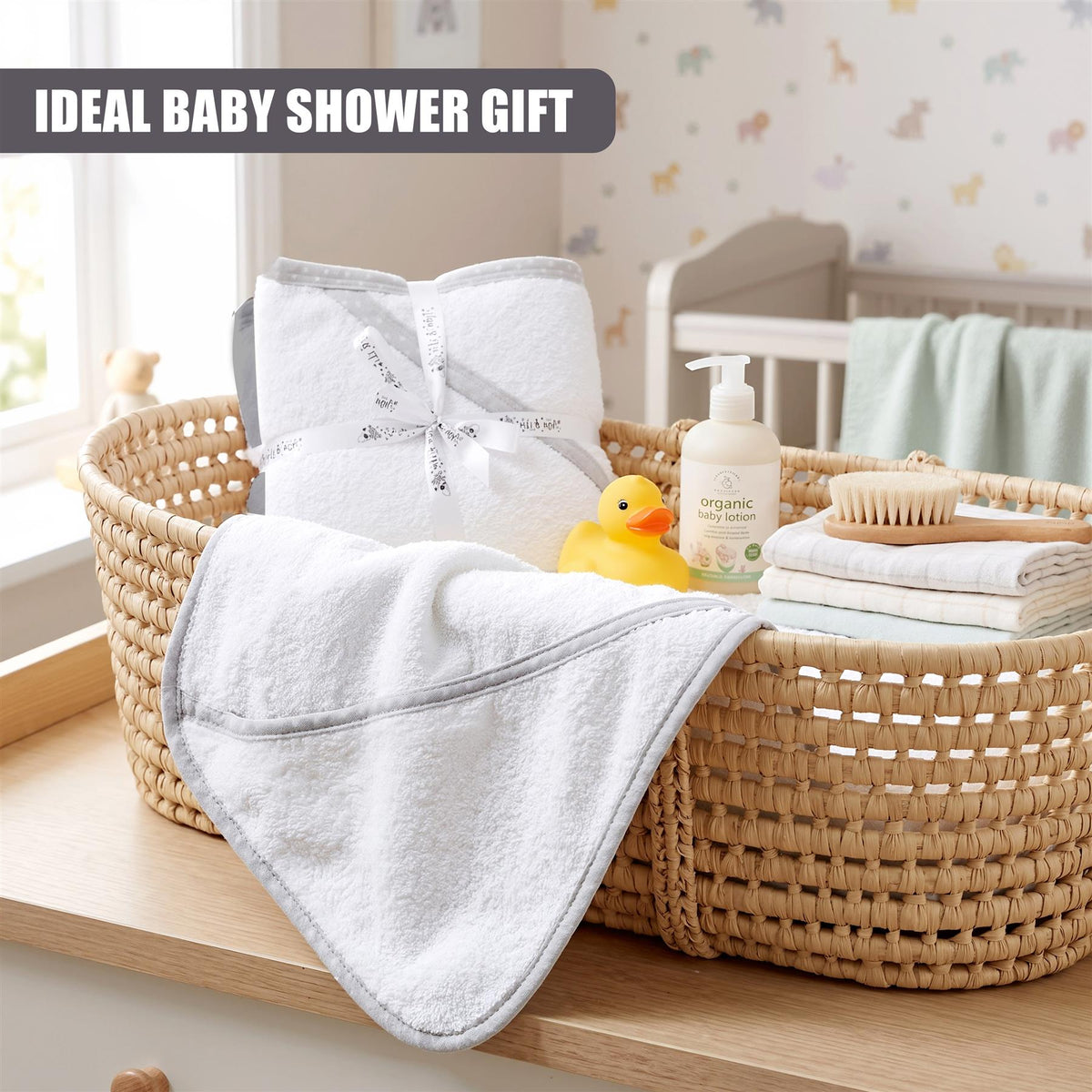 A woven basket contains two grey hooded baby towels and baby bath products, ideal for a baby shower gift
