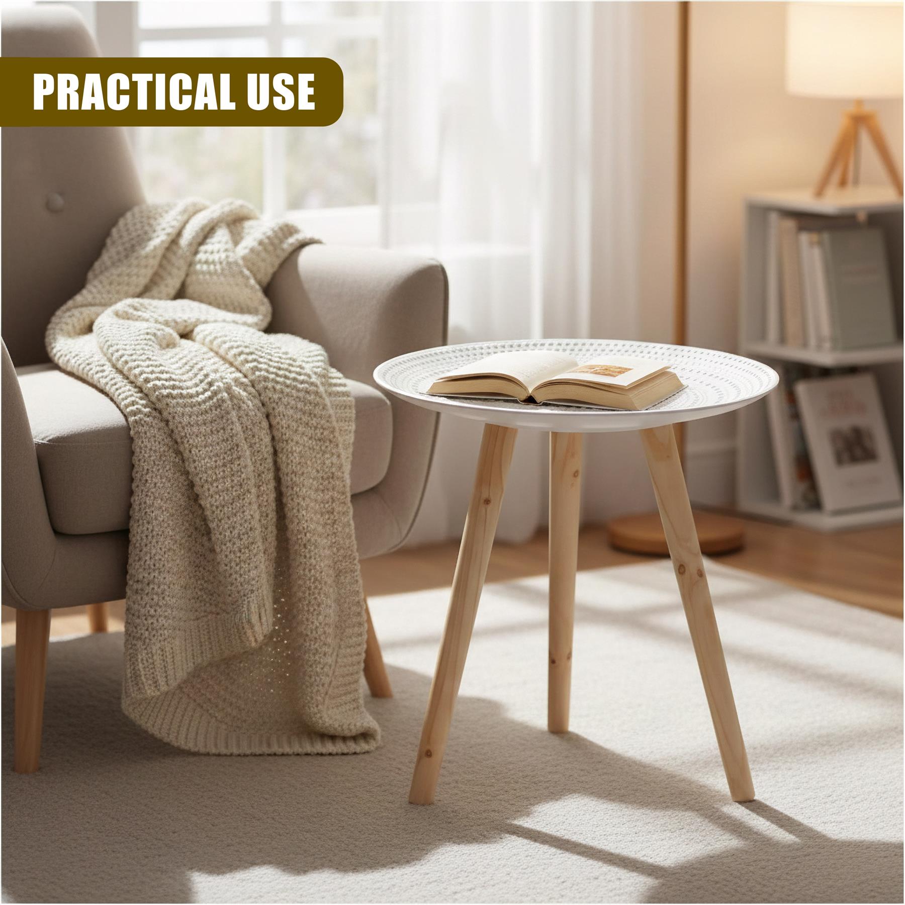 Round white side table with angled wooden legs and an open book displayed on its surface.