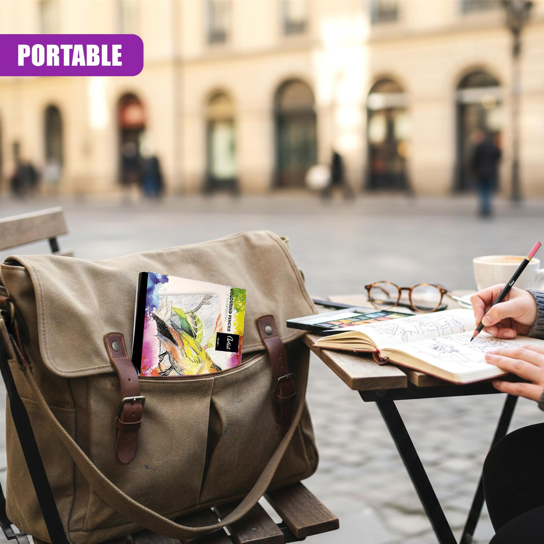 A sketchpad and drawing tools rest on a table beside a canvas bag containing art supplies.