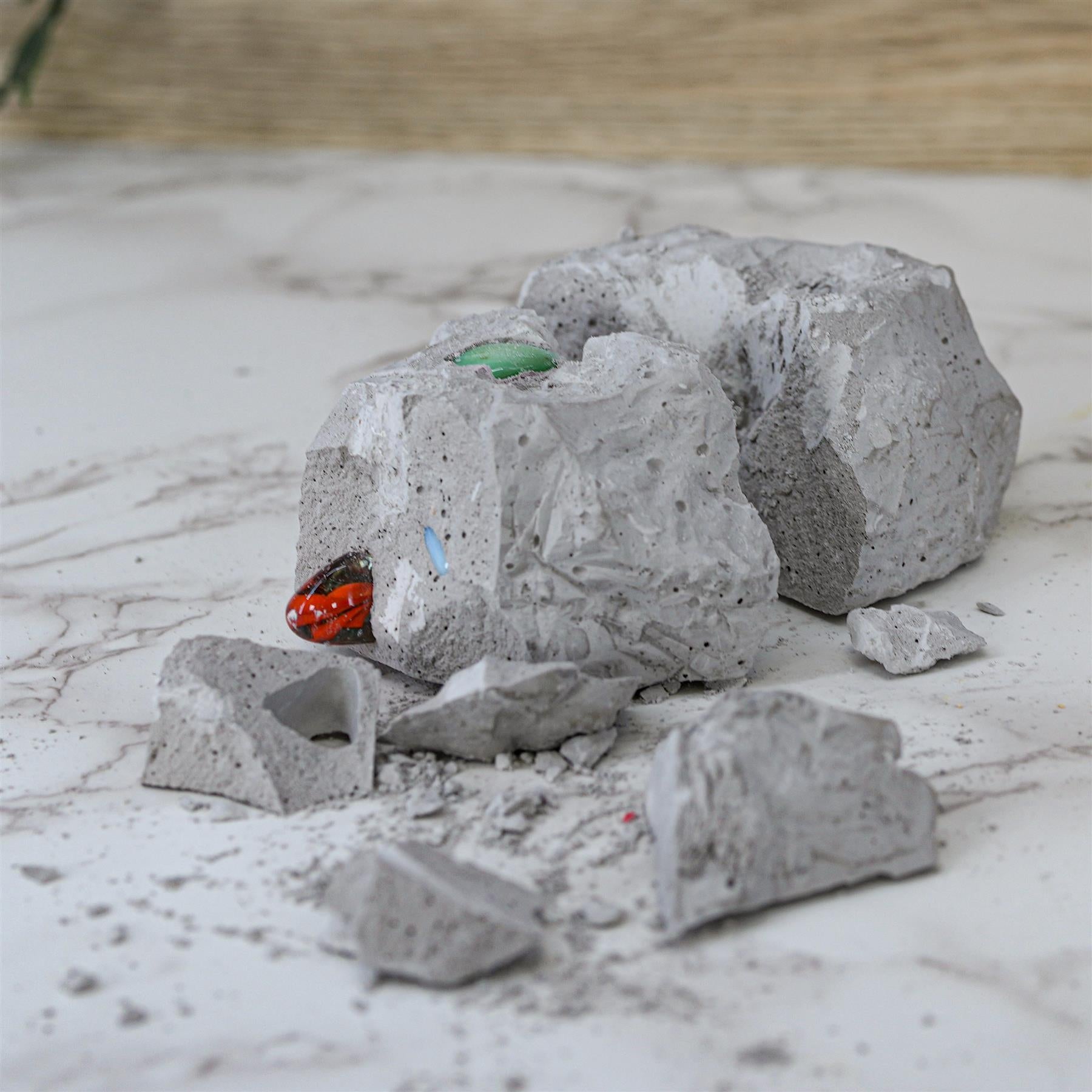 Several gray, rock-like pieces scattered with visible embedded colored gems and crystals.